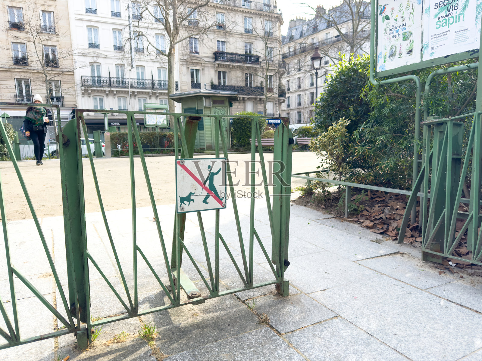 公园入口处有一块可爱的狗狗标志，背景是迷人的城市风景照片摄影图片