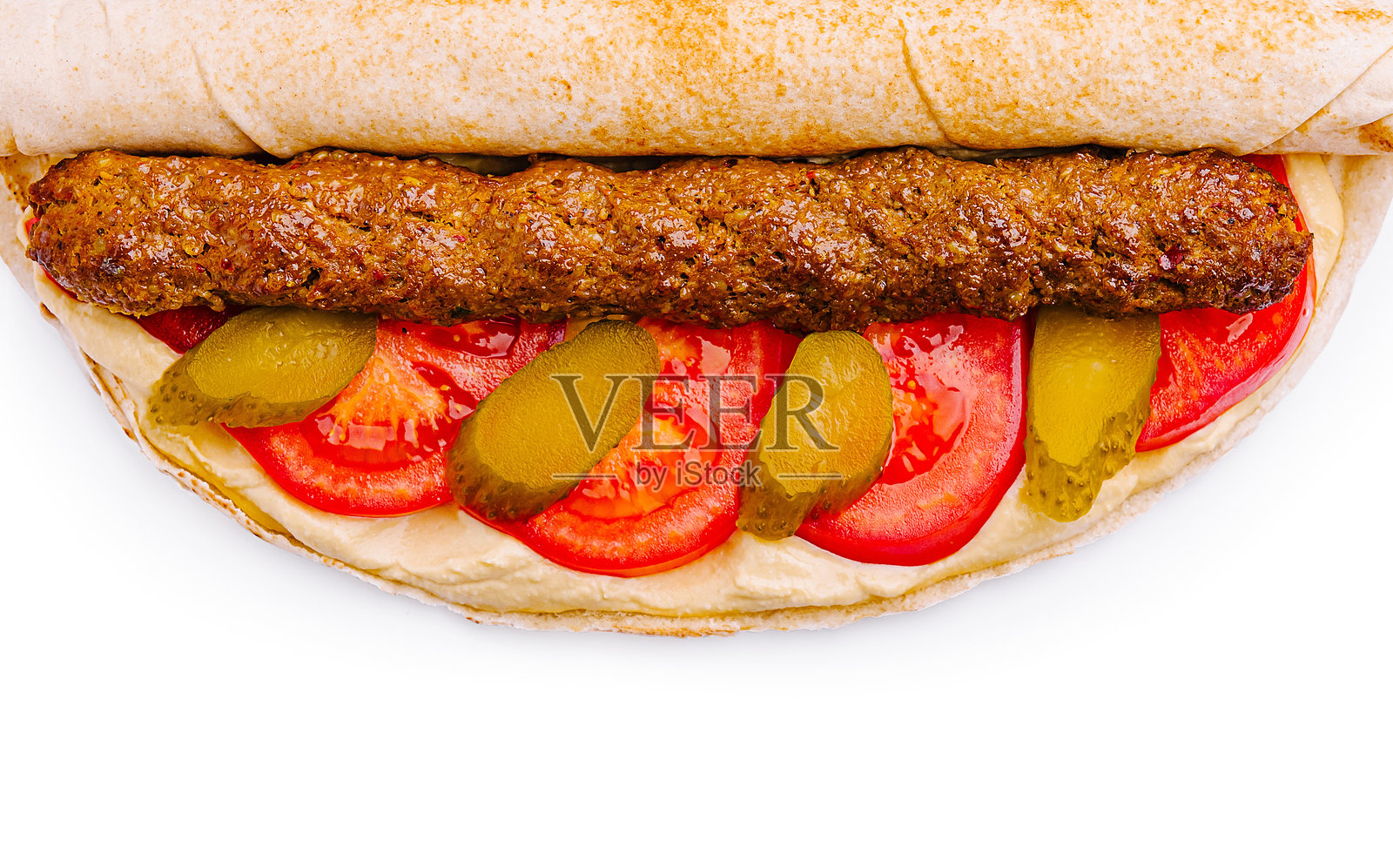 美味的卷饼，里面包裹着烤肉、新鲜蔬菜和奶油酱，背景为白色。照片摄影图片