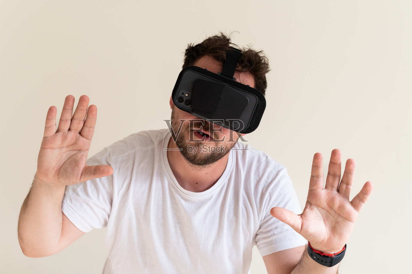 男子使用智能手机头戴设备与虚拟现实互动照片摄影图片