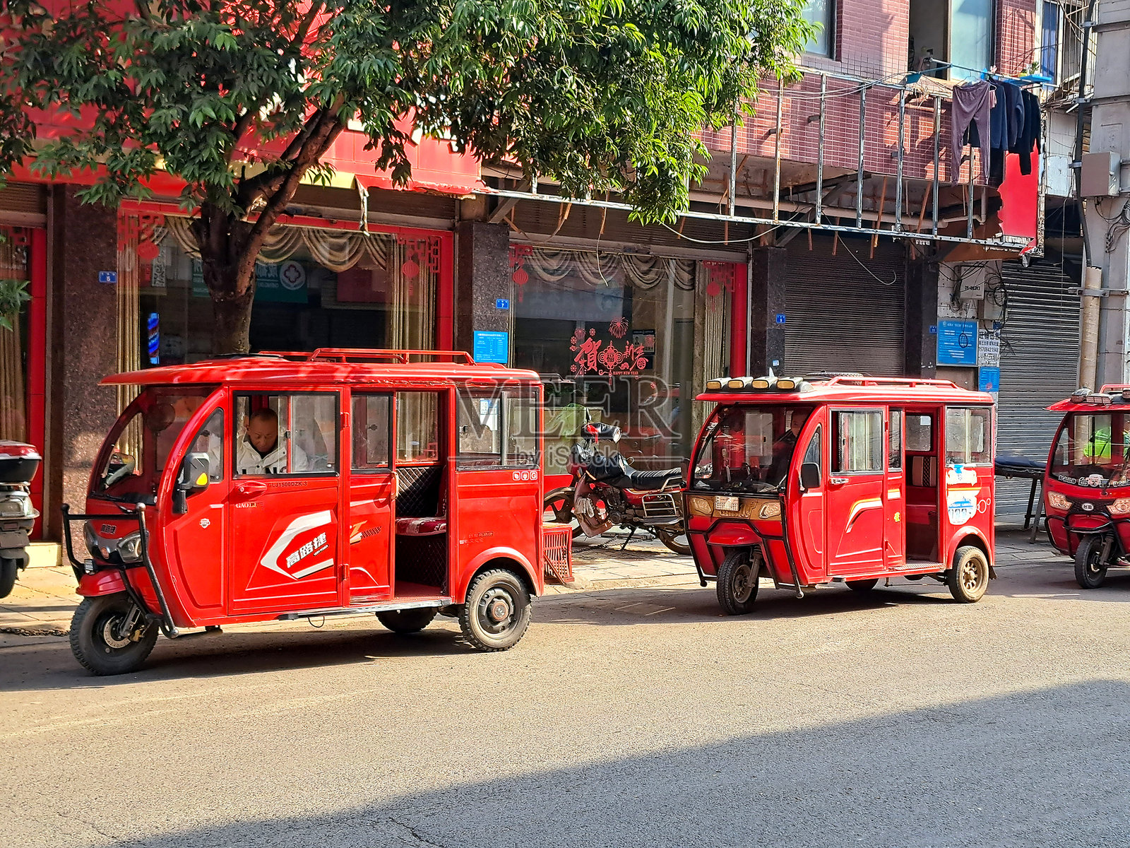 中国街道上的乘客电动三轮出租车照片摄影图片