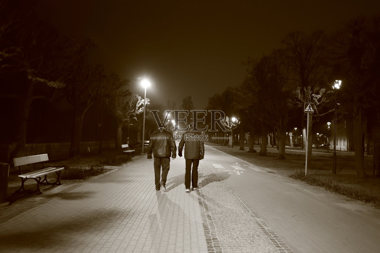 波兰索波特 - 2025年1月22日：两名男子在夜间散步，正面照明，黑白照片照片摄影图片