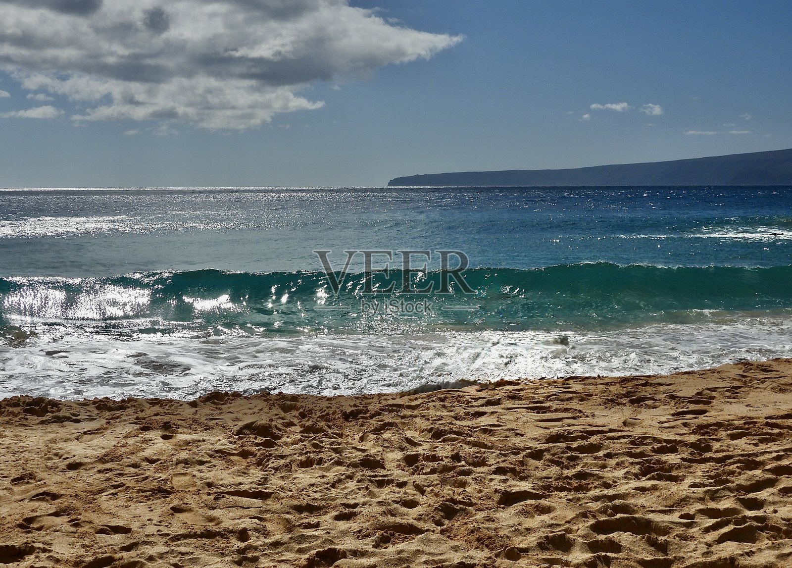 强大的十二英尺高的海浪即将冲击毛伊岛马肯纳州立公园的金棕色奥内洛阿海滩或大海滩。照片摄影图片