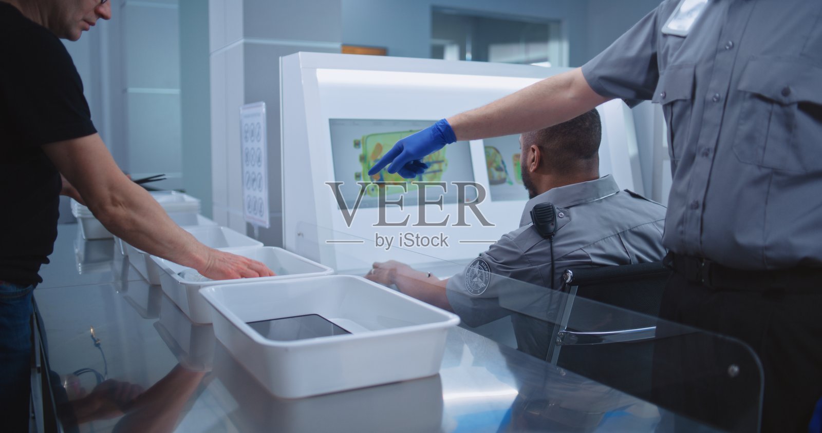 机场安检：不同种族的乘客将个人物品放入托盘进行检查照片摄影图片