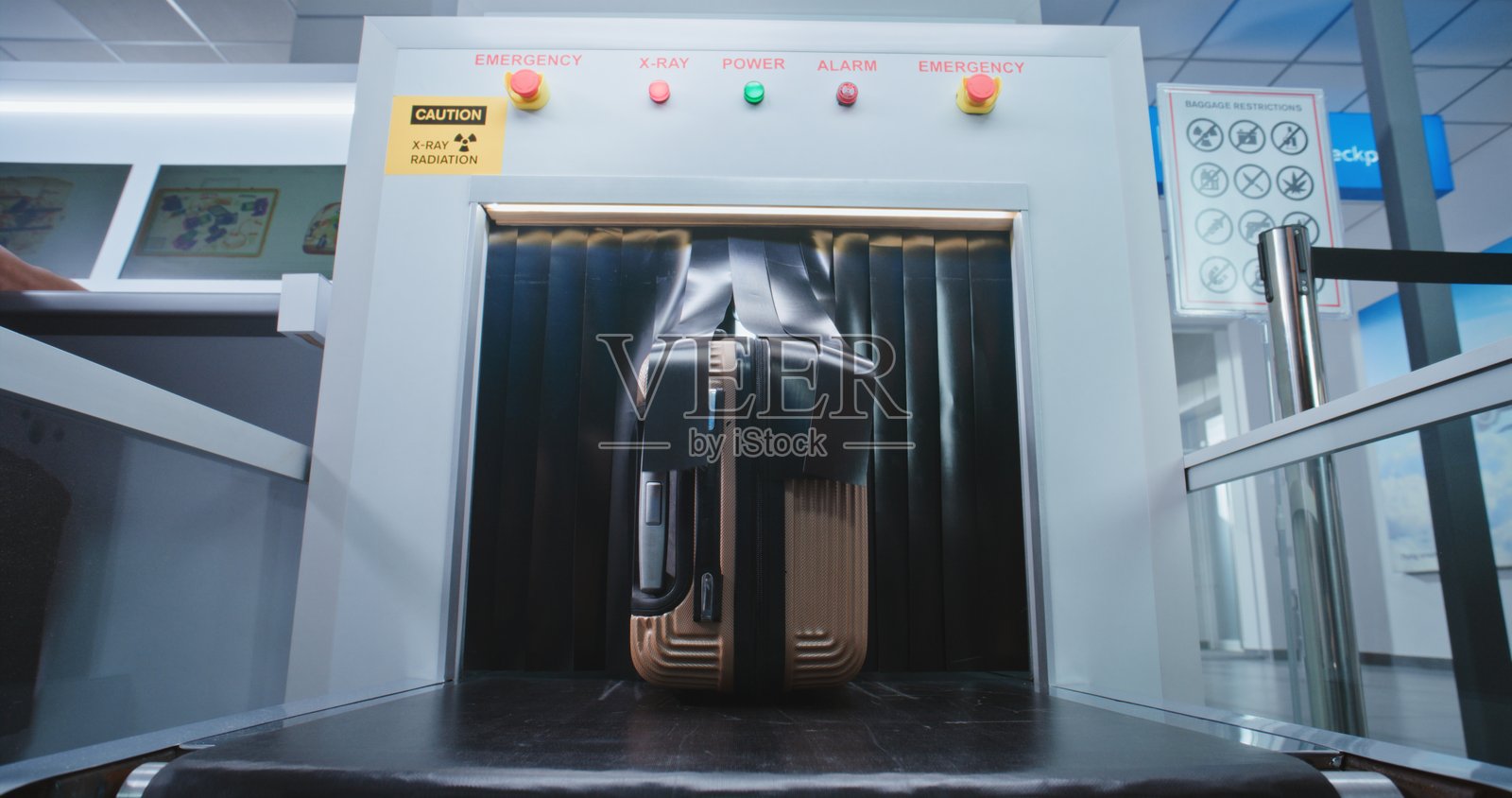 机场安检：乘客在行李筛查后从传送带上取回行李箱照片摄影图片