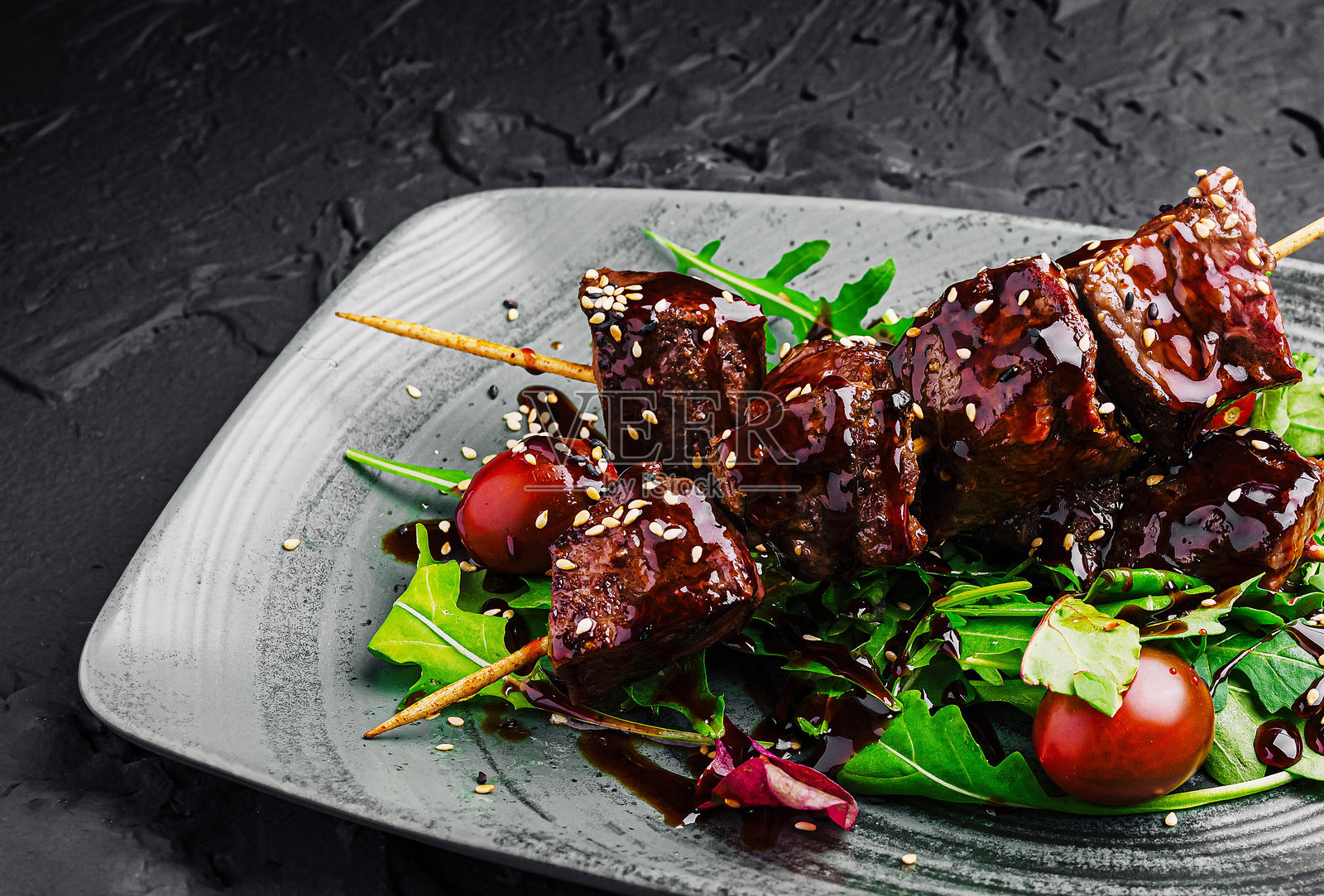 烤串配新鲜绿叶蔬菜、樱桃番茄和芝麻照片摄影图片