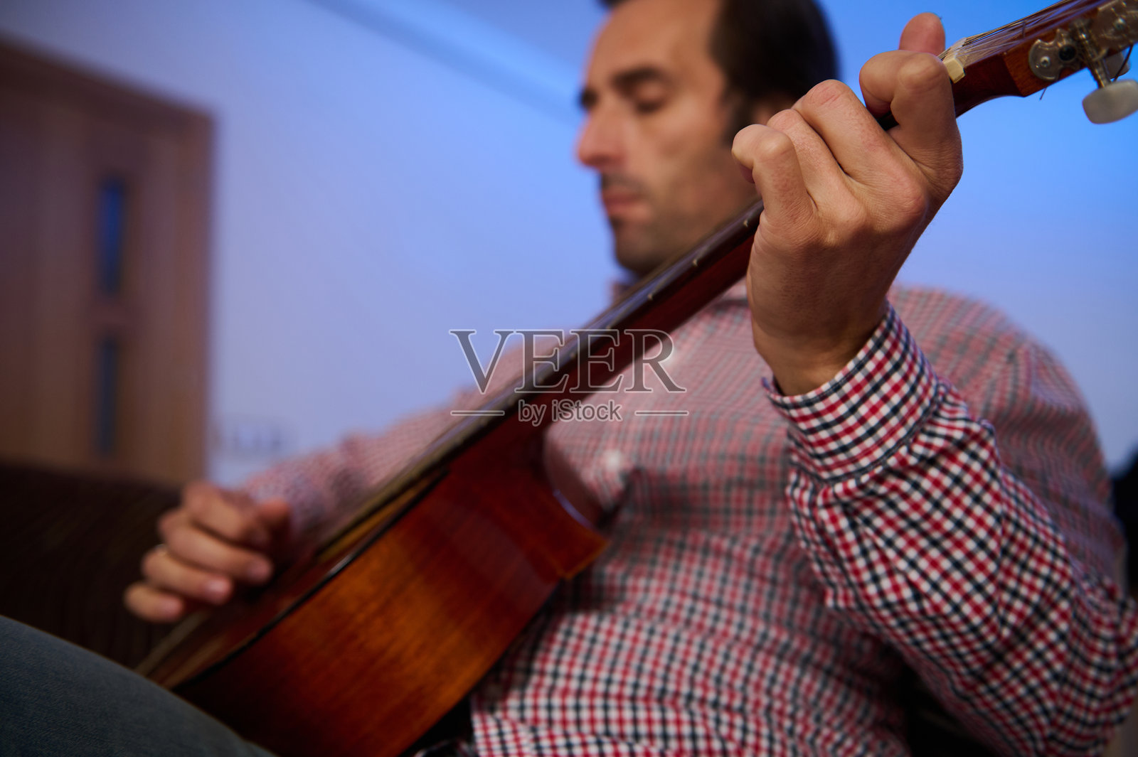 在舒适的室内环境中弹奏原声吉他的男人照片摄影图片