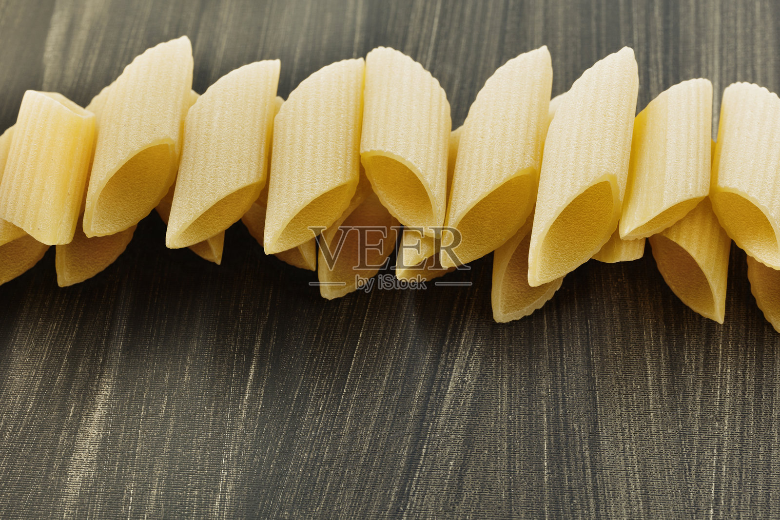 黑色桌子上的生意大利笔管面照片摄影图片