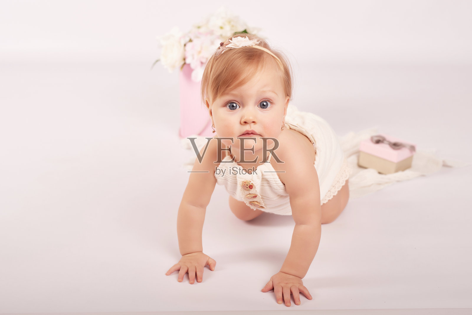 可爱的搞笑宝宝戴着花帽子。复活节贺卡，留白供您填写文字。复活节假期海报。母亲节祝贺。可爱的小女孩。儿童保护日。照片摄影图片