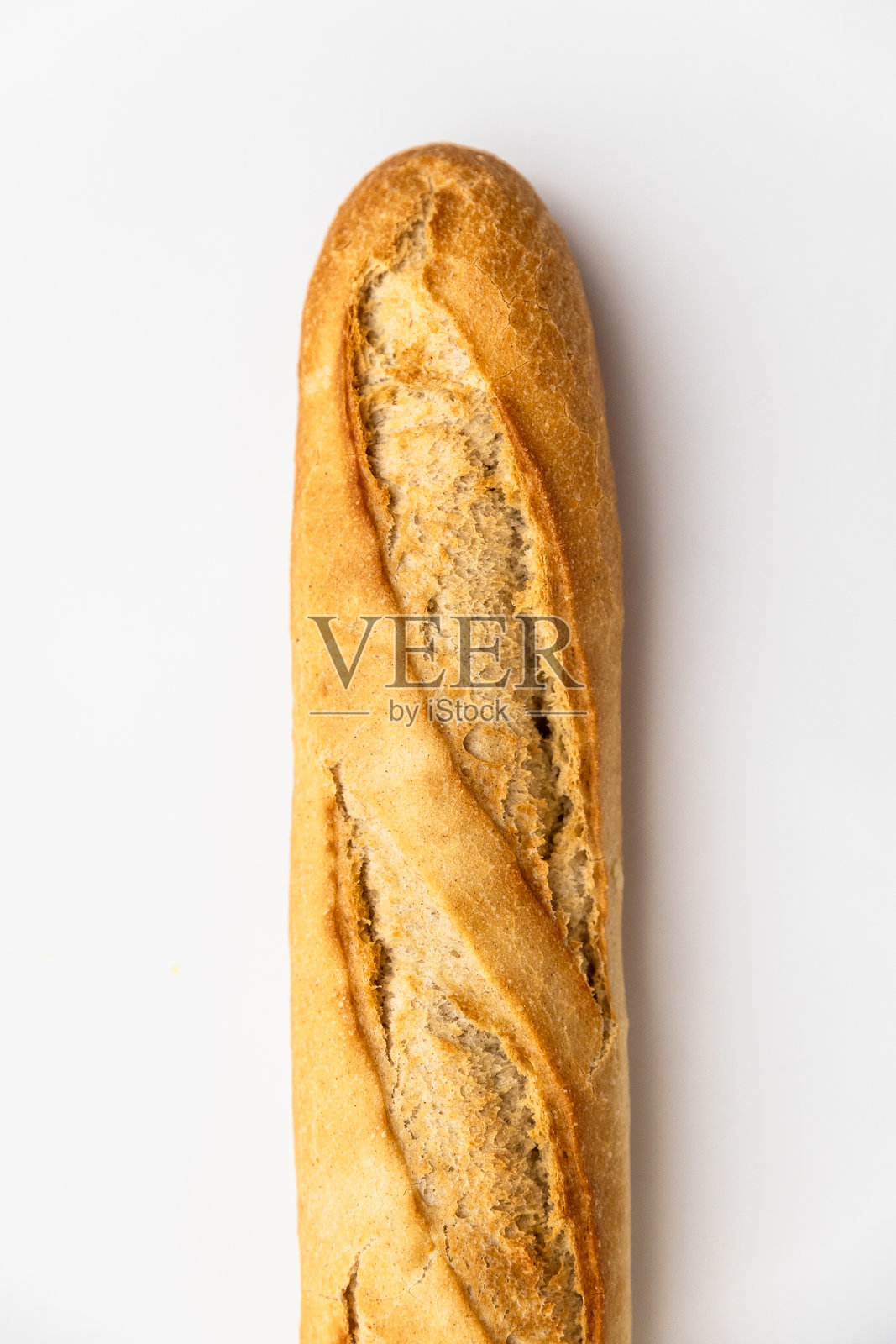 白色背景上的半截法式长棍面包特写。新鲜面包的微距拍摄，有机烘焙食品。照片摄影图片