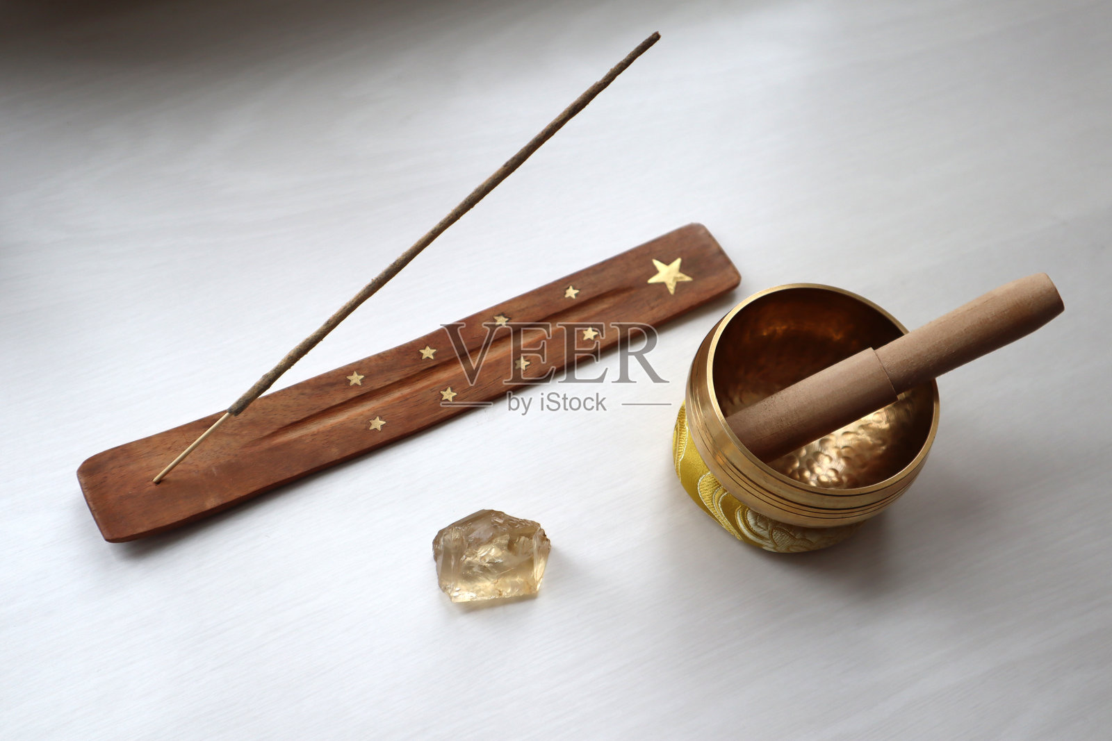 印度香、唱碗和黄水晶放在白色桌子上。照片摄影图片