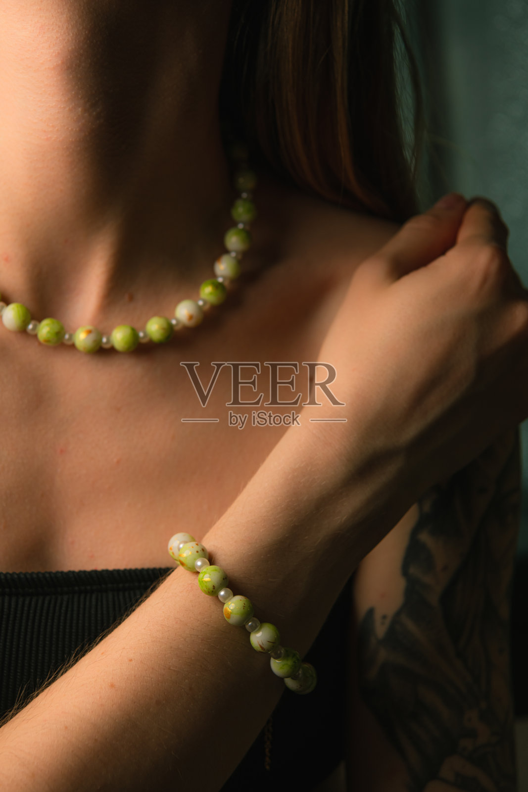 女孩佩戴的翡翠和珍珠手工项链与手链照片摄影图片