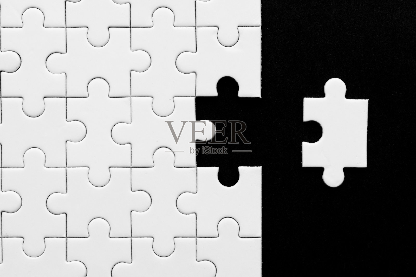 黑色背景上的白色拼图缺少几块拼图。照片摄影图片