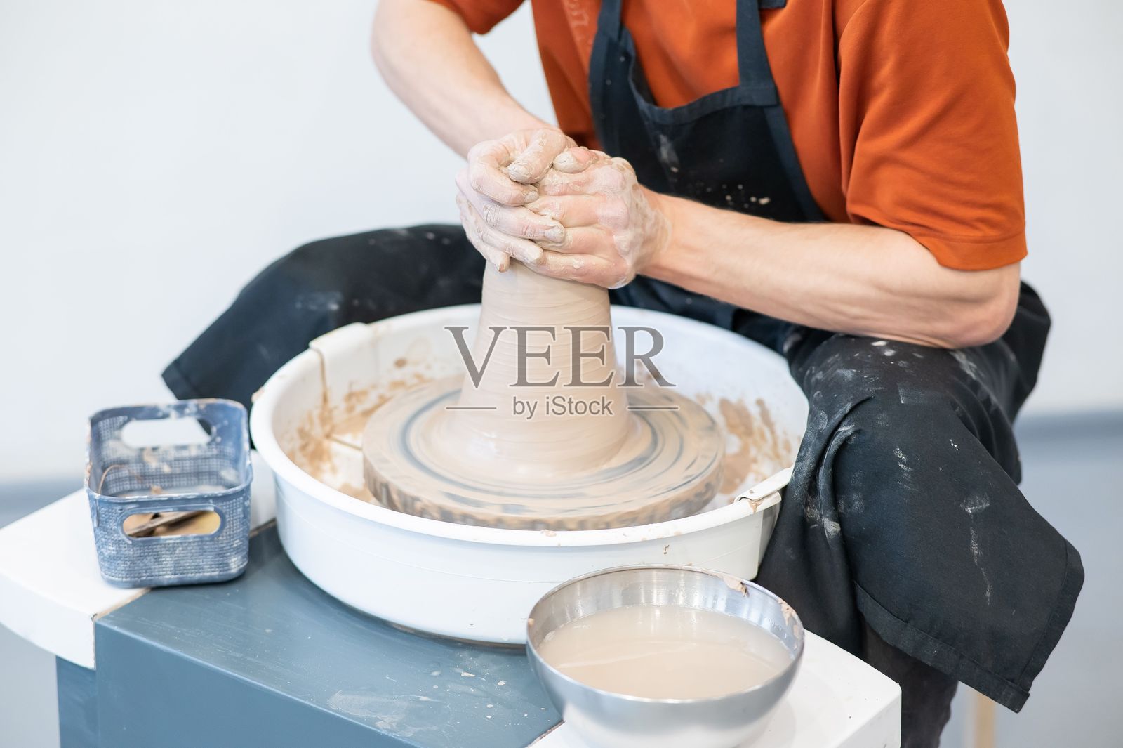 陶艺师的双手在陶轮上进行细致的工作。照片摄影图片