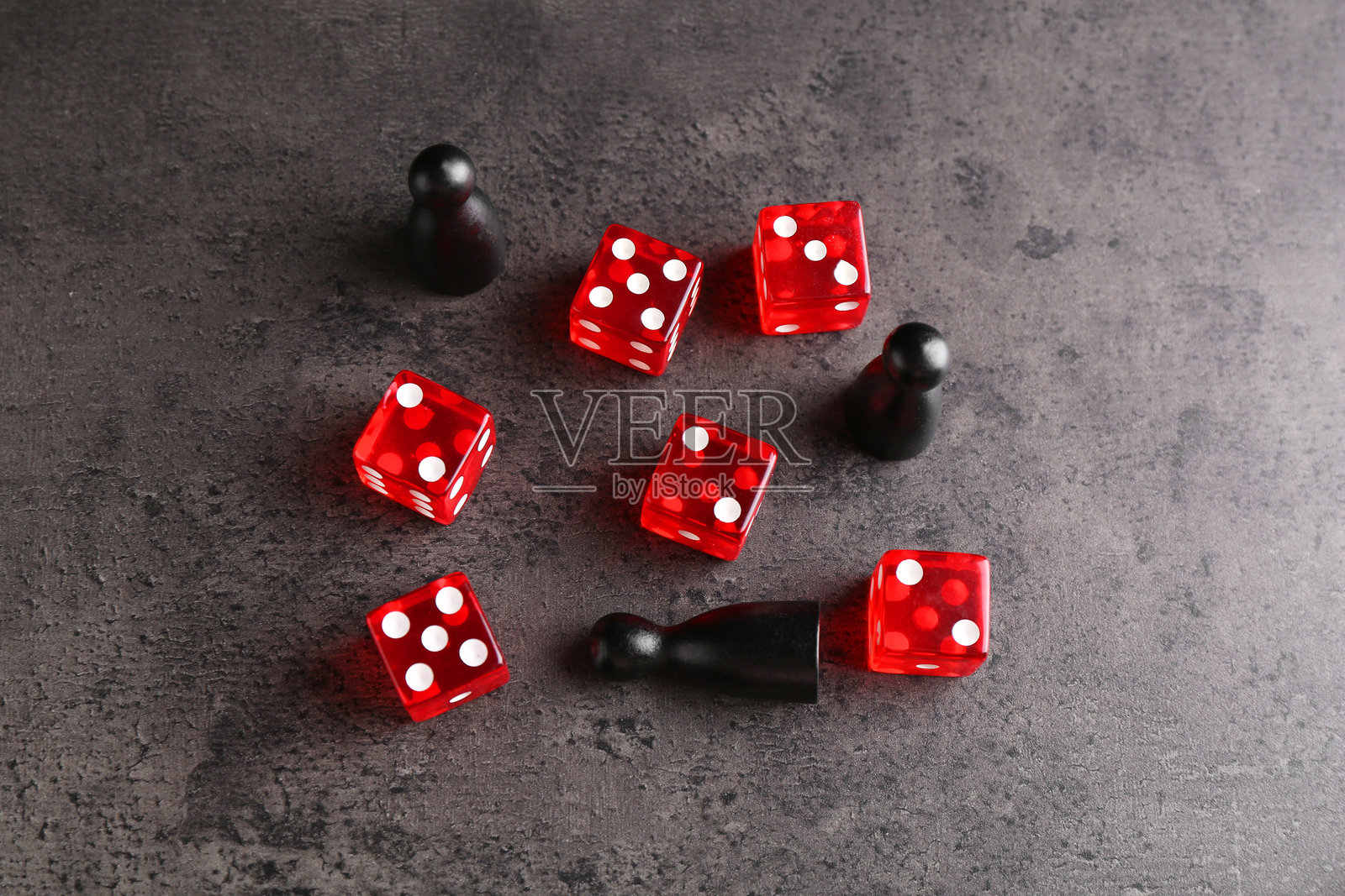 许多红色骰子和黑色游戏棋子放在灰色纹理桌面上，俯视图照片摄影图片