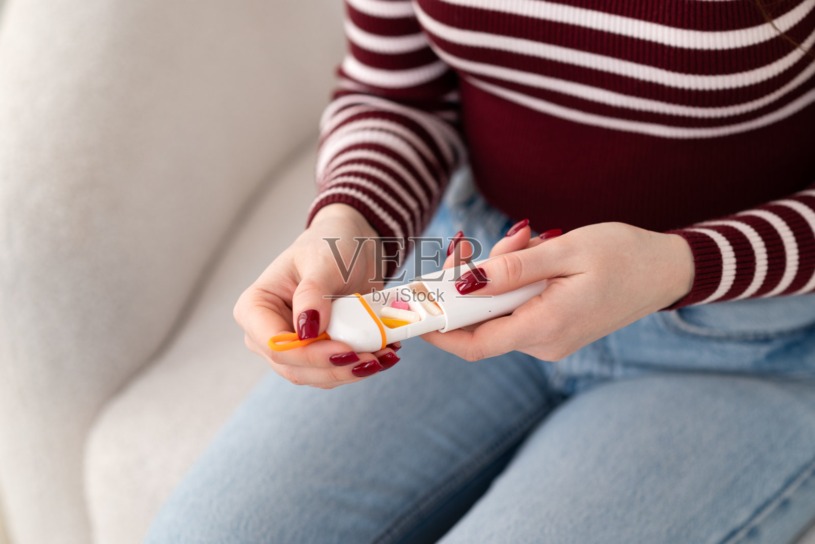 孕妇手持药物整理盒，内含补充剂和维生素。医疗保健、孕期和日常药物管理以支持怀孕。照片摄影图片