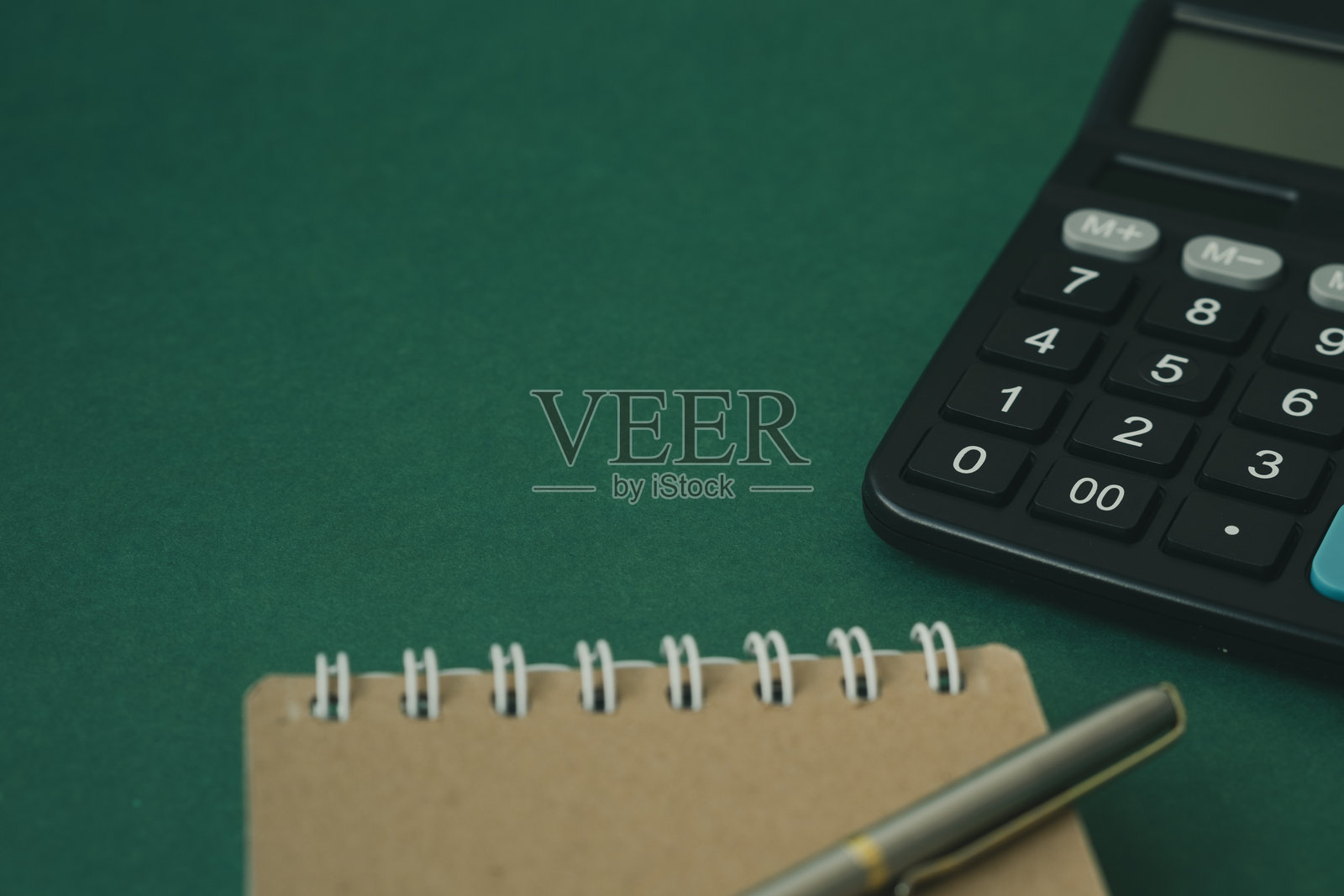 绿色背景上的计算器和记事本，一个可以抄写的地方照片摄影图片