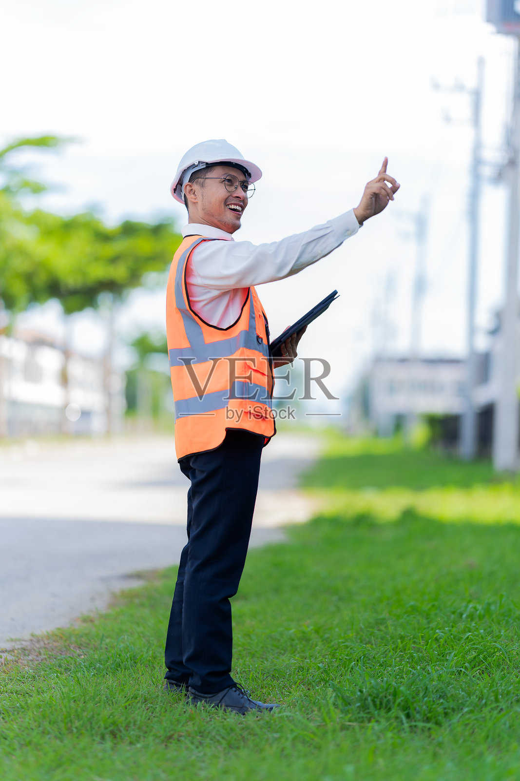 首席工程师在检查一栋正在建设中的两层住宅项目时，正在平板电脑上做笔记。照片摄影图片