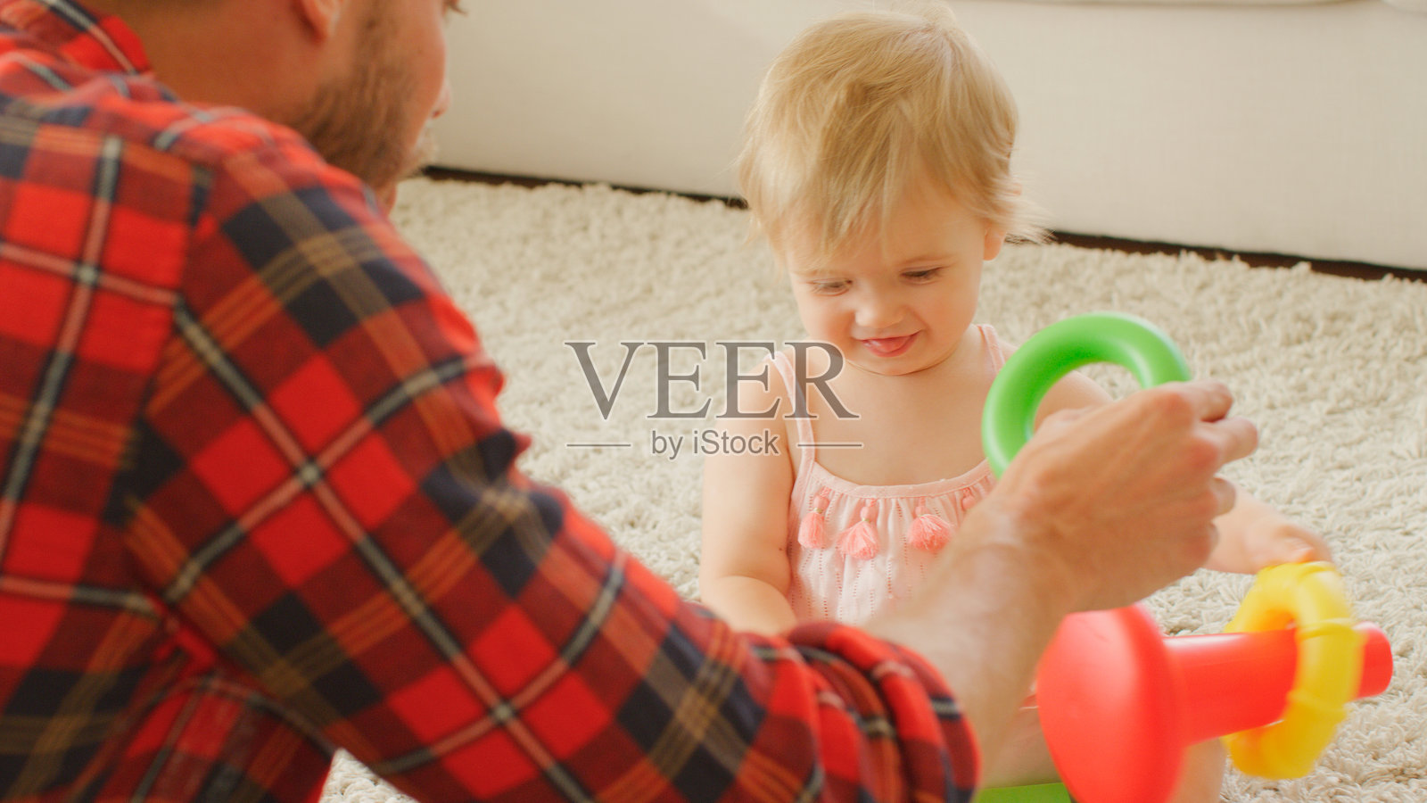 父亲在家中与小女儿一起玩塑料堆叠玩具照片摄影图片