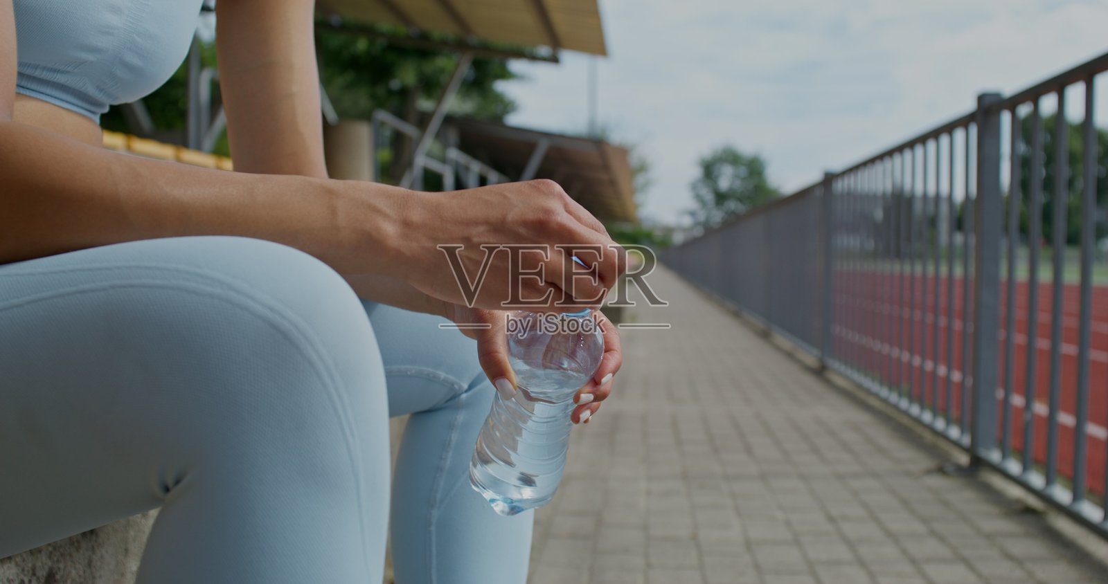 一位女性在体育场休息。照片摄影图片