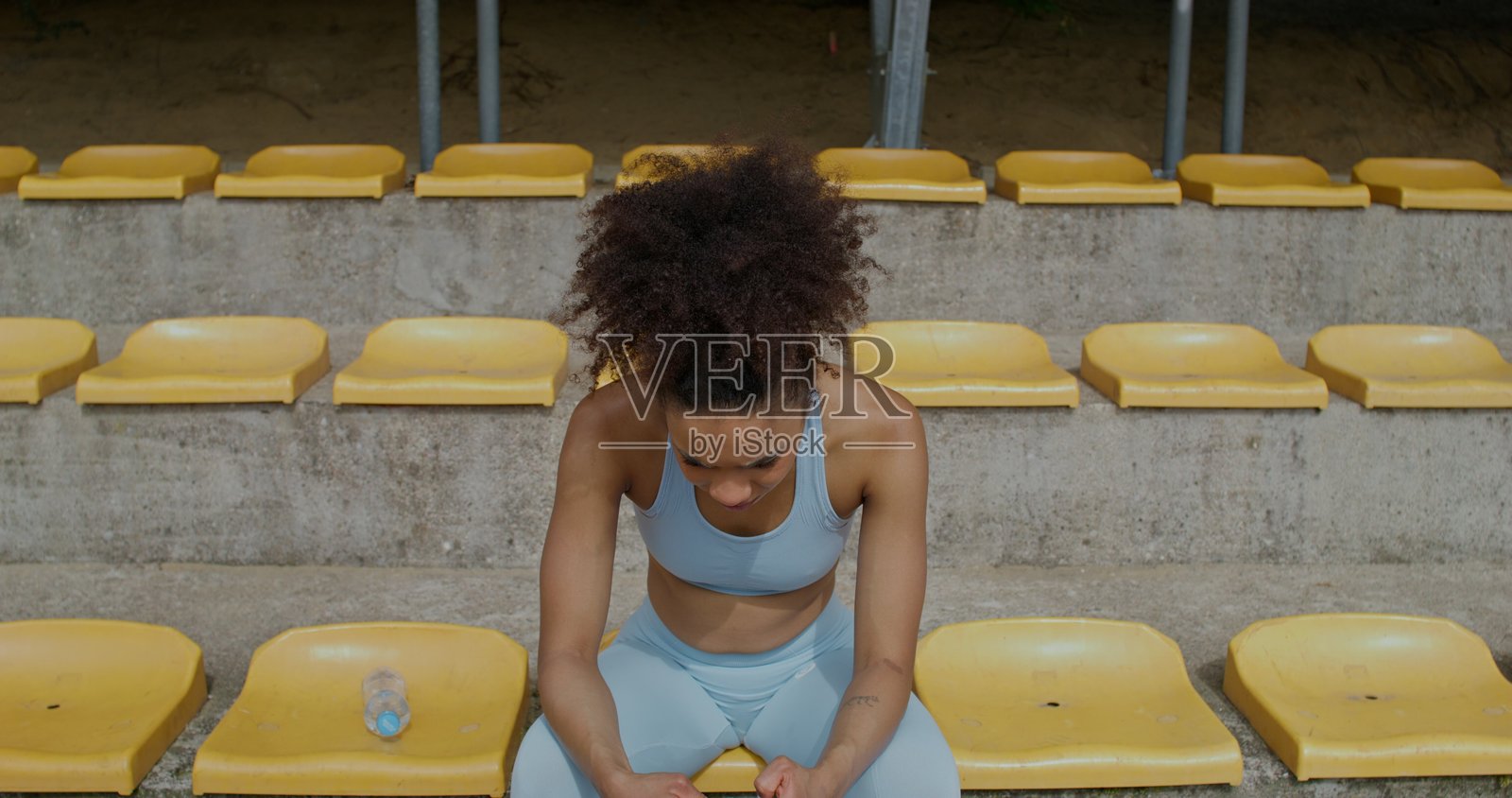 一位女性在体育场使用手机照片摄影图片