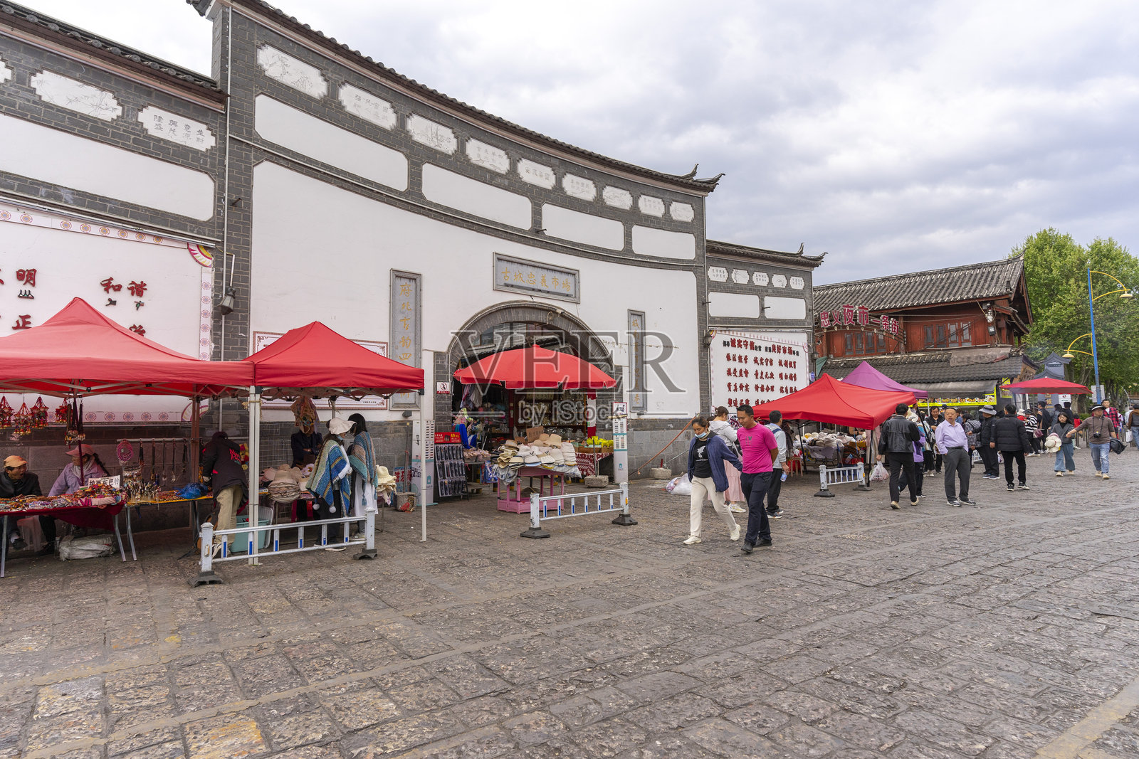 中国丽江古城的当地人在跳蚤市场上出售商品。照片摄影图片