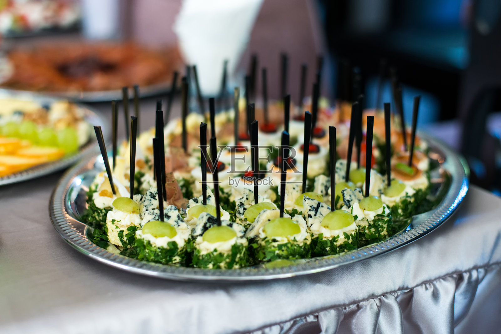 节日小吃，餐饮服务。各种小吃。沙拉、寿司和自助餐菜肴的组合。肉类、鱼类、奶酪、沙拉、水果和蔬菜、酱汁和开胃小菜，适合庆祝节日活动。照片摄影图片