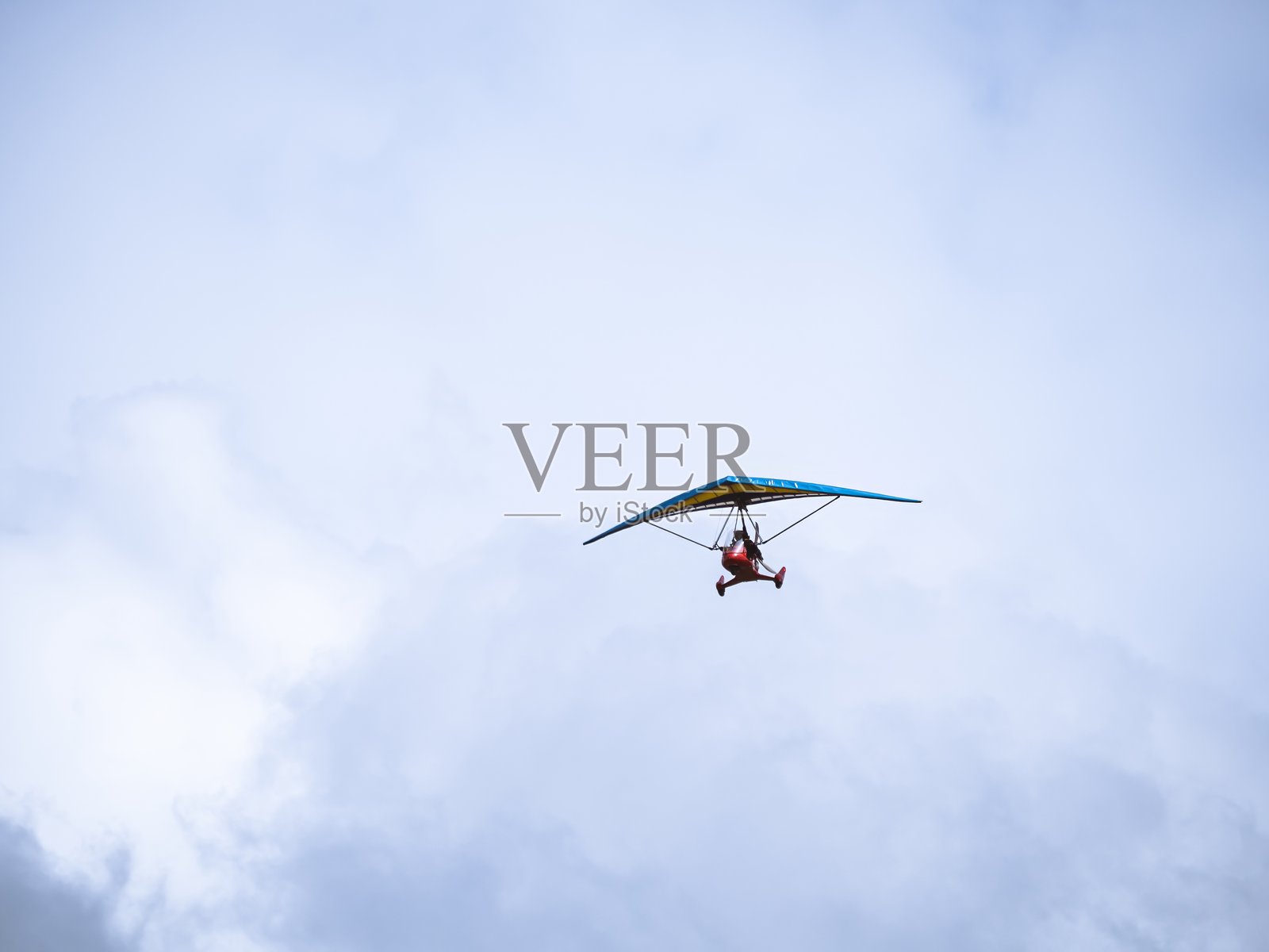 超轻型三轮飞机在多云的天空中飞行照片摄影图片