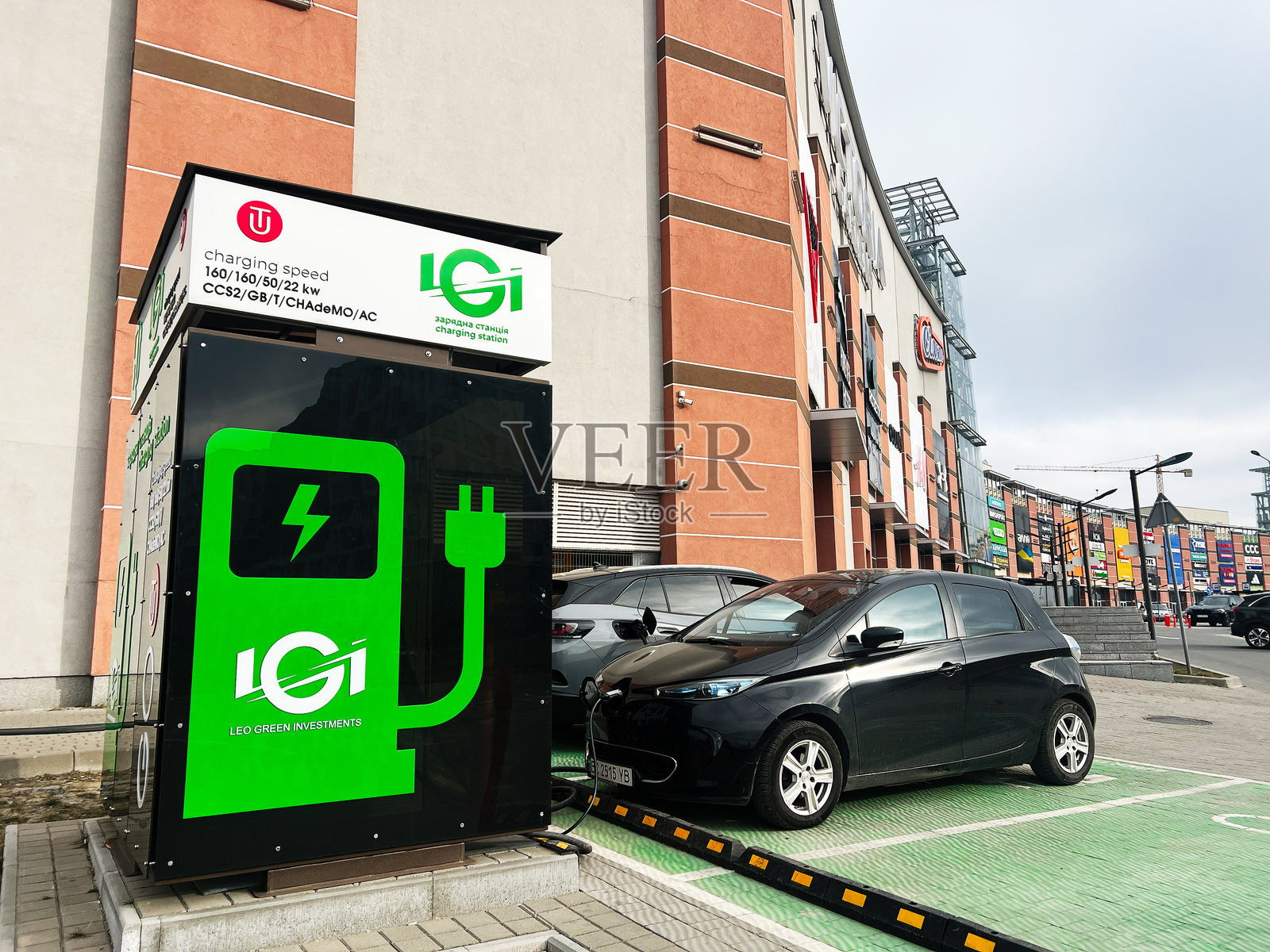 停在城市电动汽车充电站的雷诺Zoe电动车，带有绿色环保品牌标识照片摄影图片