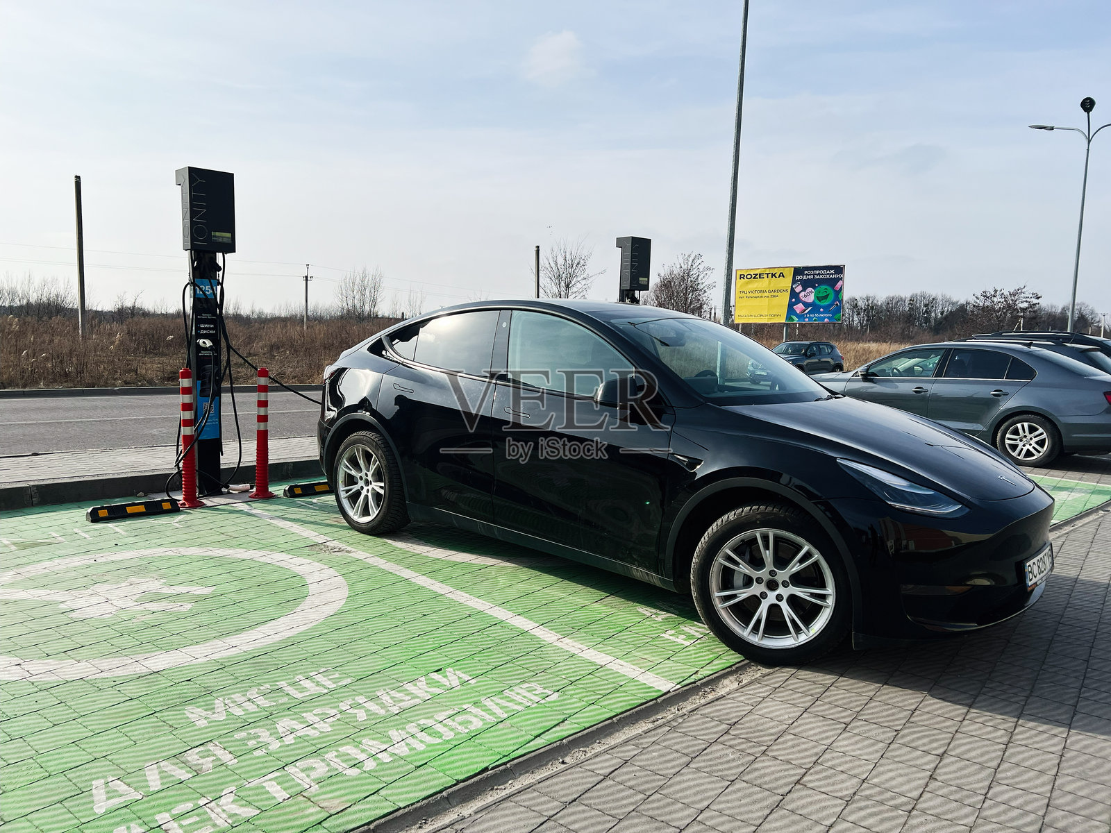 白天时段在公共充电站的电动特斯拉Model Y汽车照片摄影图片