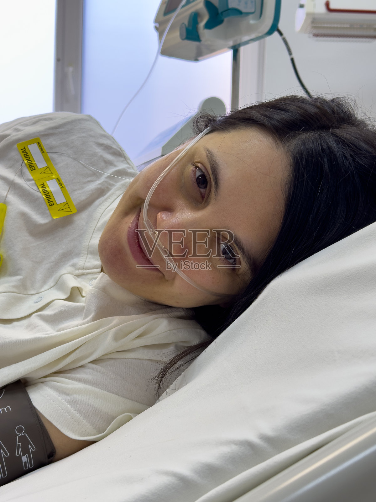 医院病床上微笑的女性，佩戴鼻导管照片摄影图片