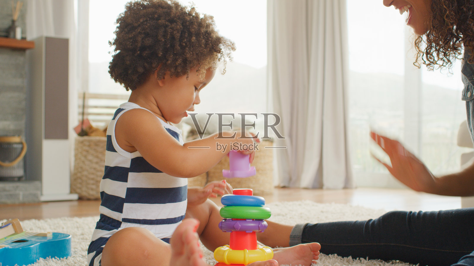 母亲和女儿在家里一起玩塑料堆叠玩具照片摄影图片