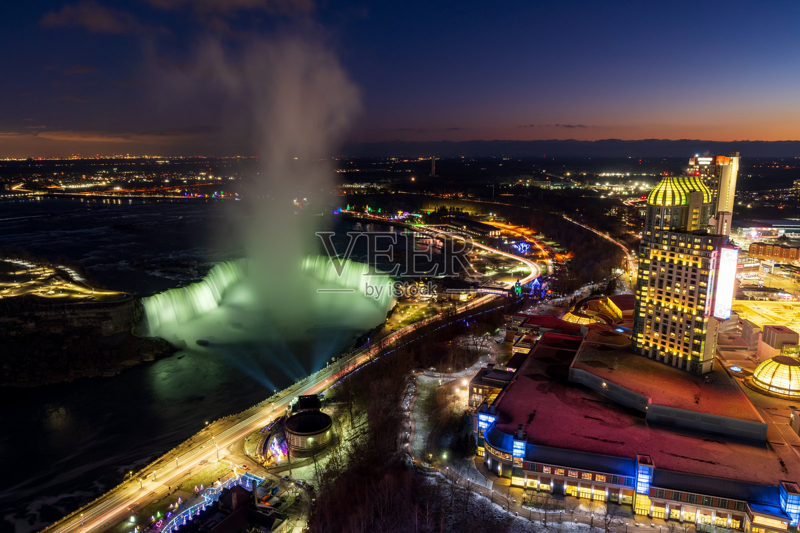 马蹄铁瀑布冬季灯光照明在黄昏时分。尼亚加拉大瀑布市市中心的天际线。令人惊叹的风景从黄昏到夜晚。照片摄影图片