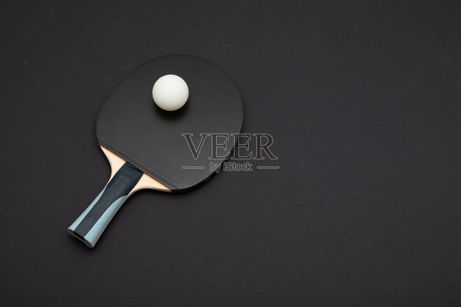 专业黑色乒乓球拍与白色球在深色背景上照片摄影图片