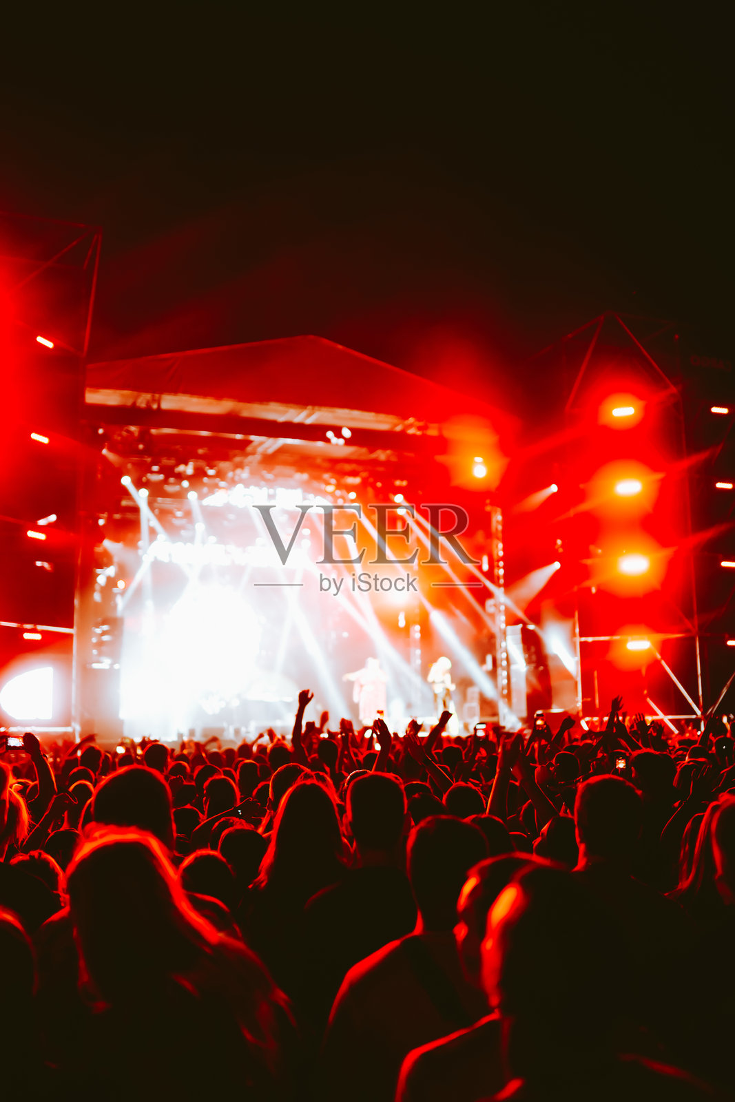 音乐会上的人群。舞台灯光和举起的手。照片摄影图片