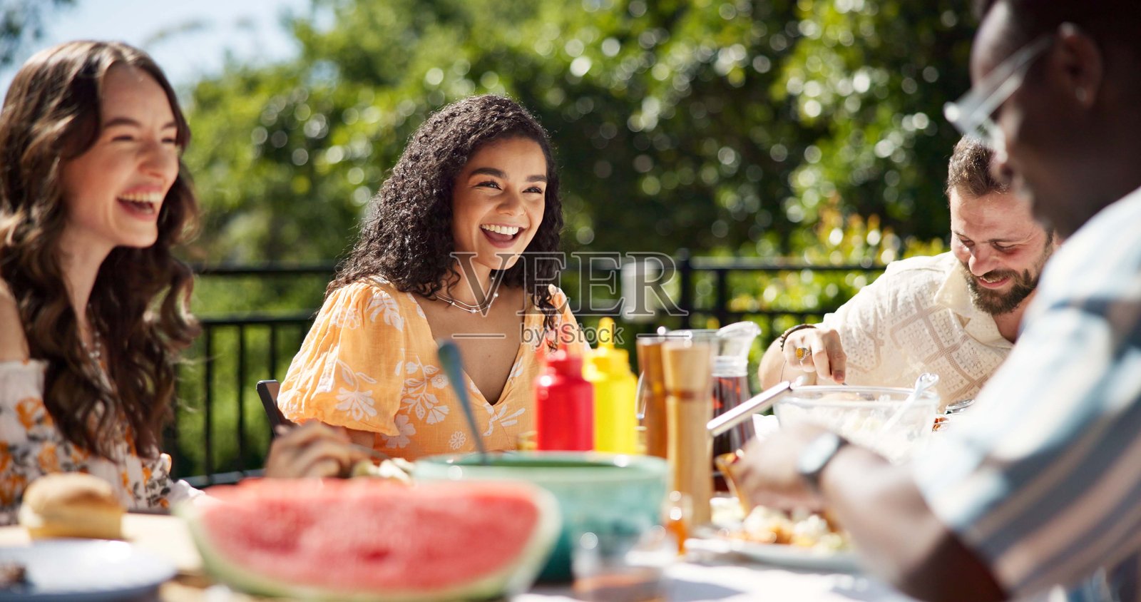 朋友们在户外庆祝新年派对，享用午餐，欢笑或相聚在一起。露台上，人们在社交聚会上快乐地享用美食，欢庆团聚，节日或轻松的对话。照片摄影图片
