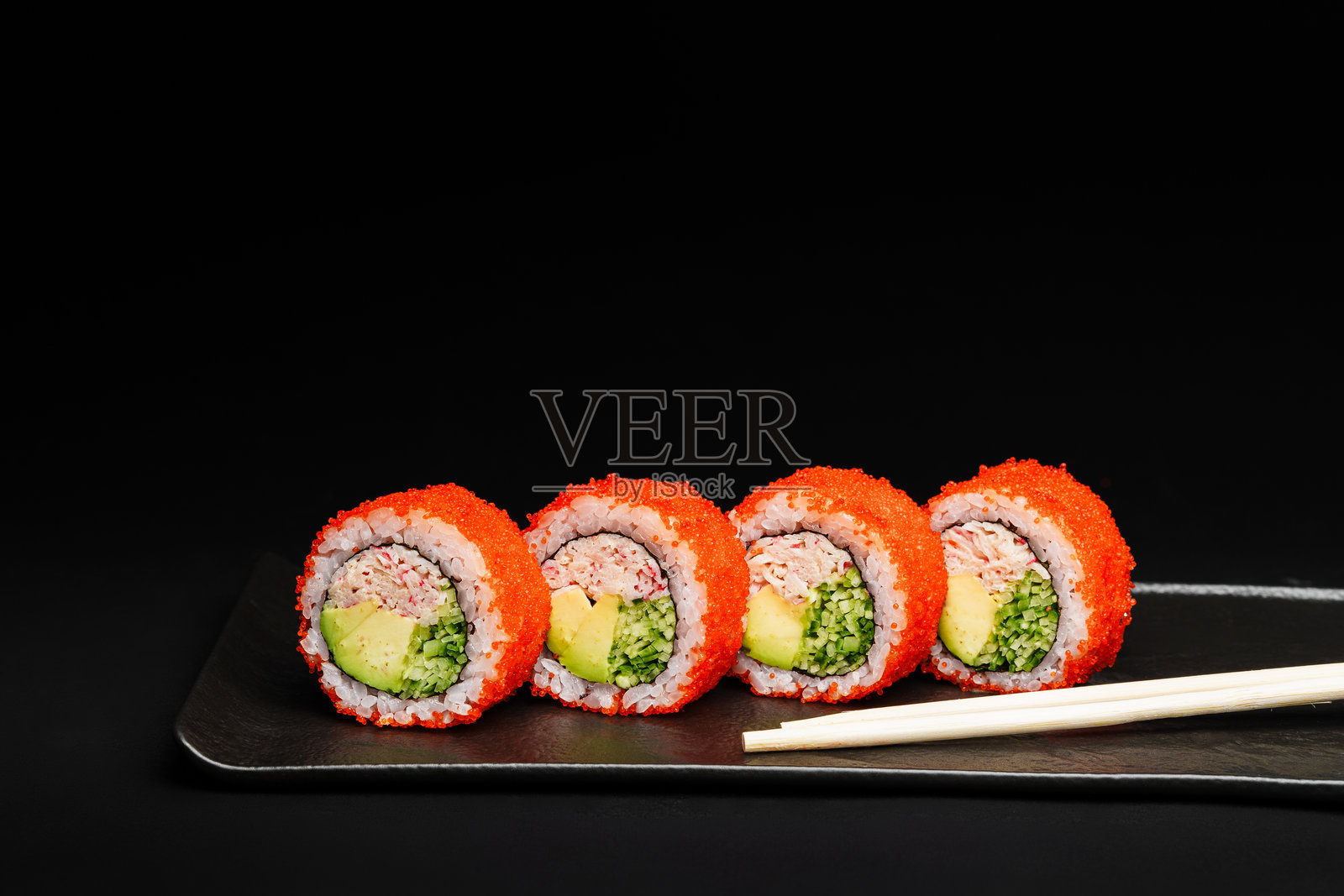 美味的新鲜三文鱼寿司卷在黑色背景上精美呈现照片摄影图片