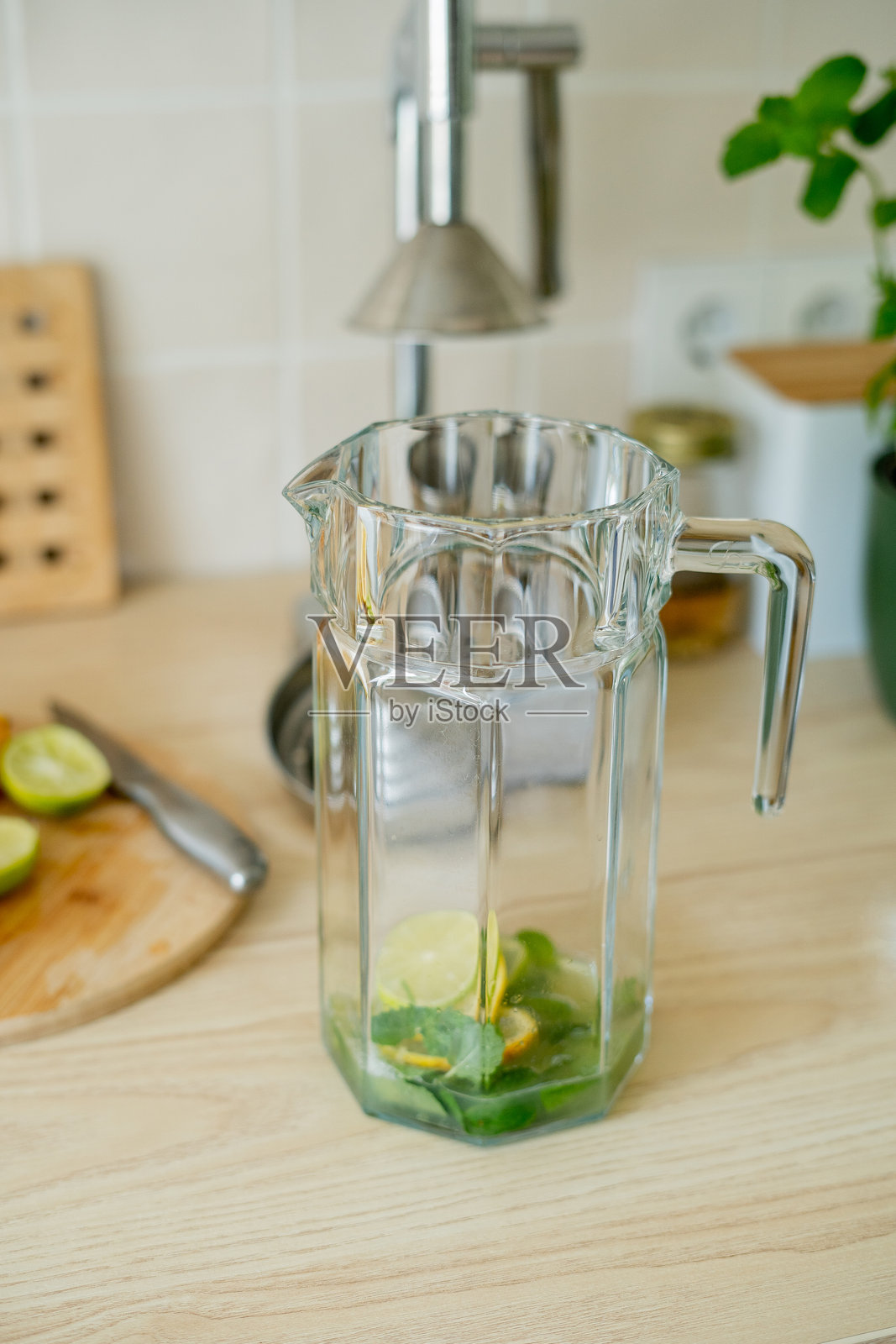 在米色光线的厨房里制作新鲜自制柠檬水。照片摄影图片