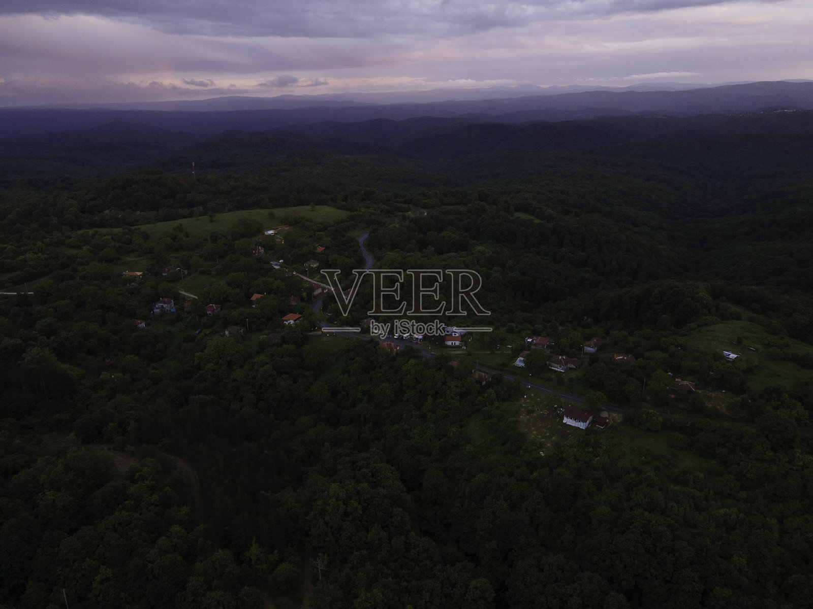 红色日出与阴郁天空映衬下的山村风景。鸟瞰图照片摄影图片