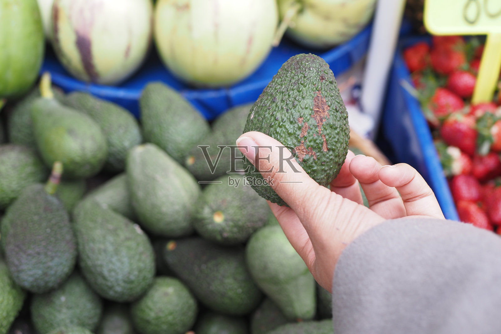 年轻女性在零售店手持鳄梨购物照片摄影图片