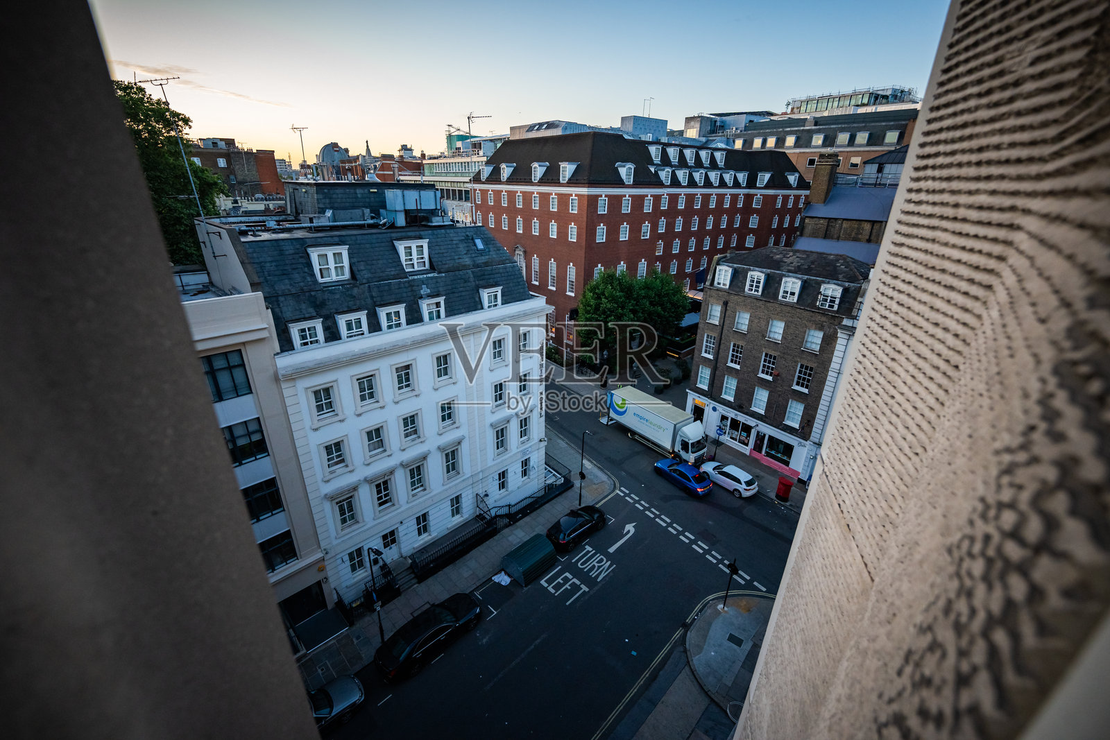 从廉价酒店窗户看到的伦敦市中心日出。旅行者英格兰之行的第一天早晨用手机拍摄。照片摄影图片