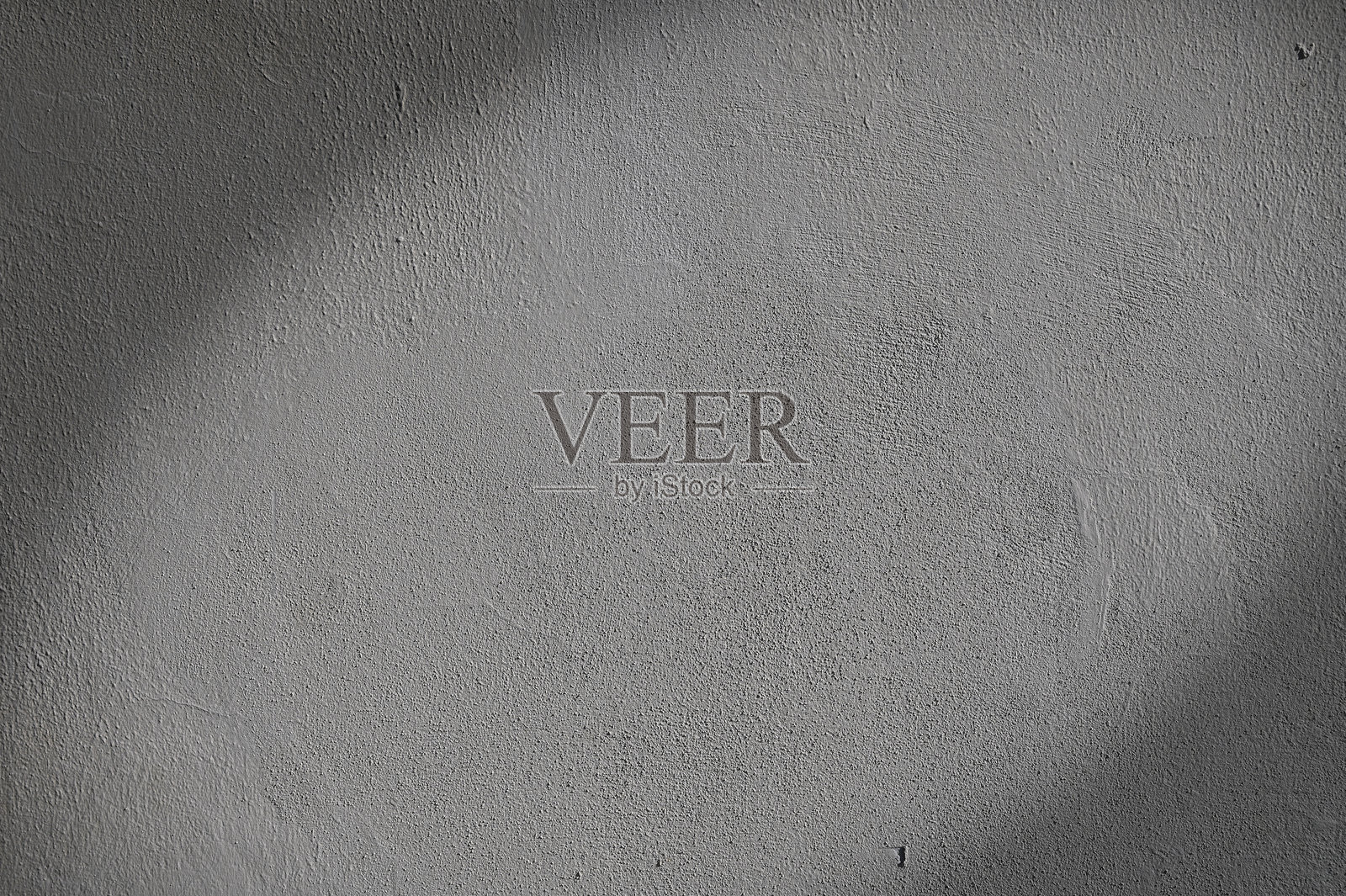 柔和的阴影在清晨的微光中，轻轻地在有纹理的灰色墙壁上舞动。照片摄影图片