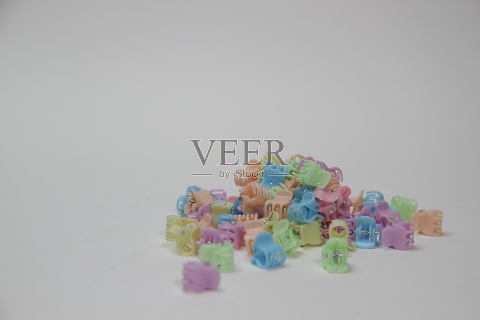 五颜六色的小发夹堆放在白色背景上照片摄影图片