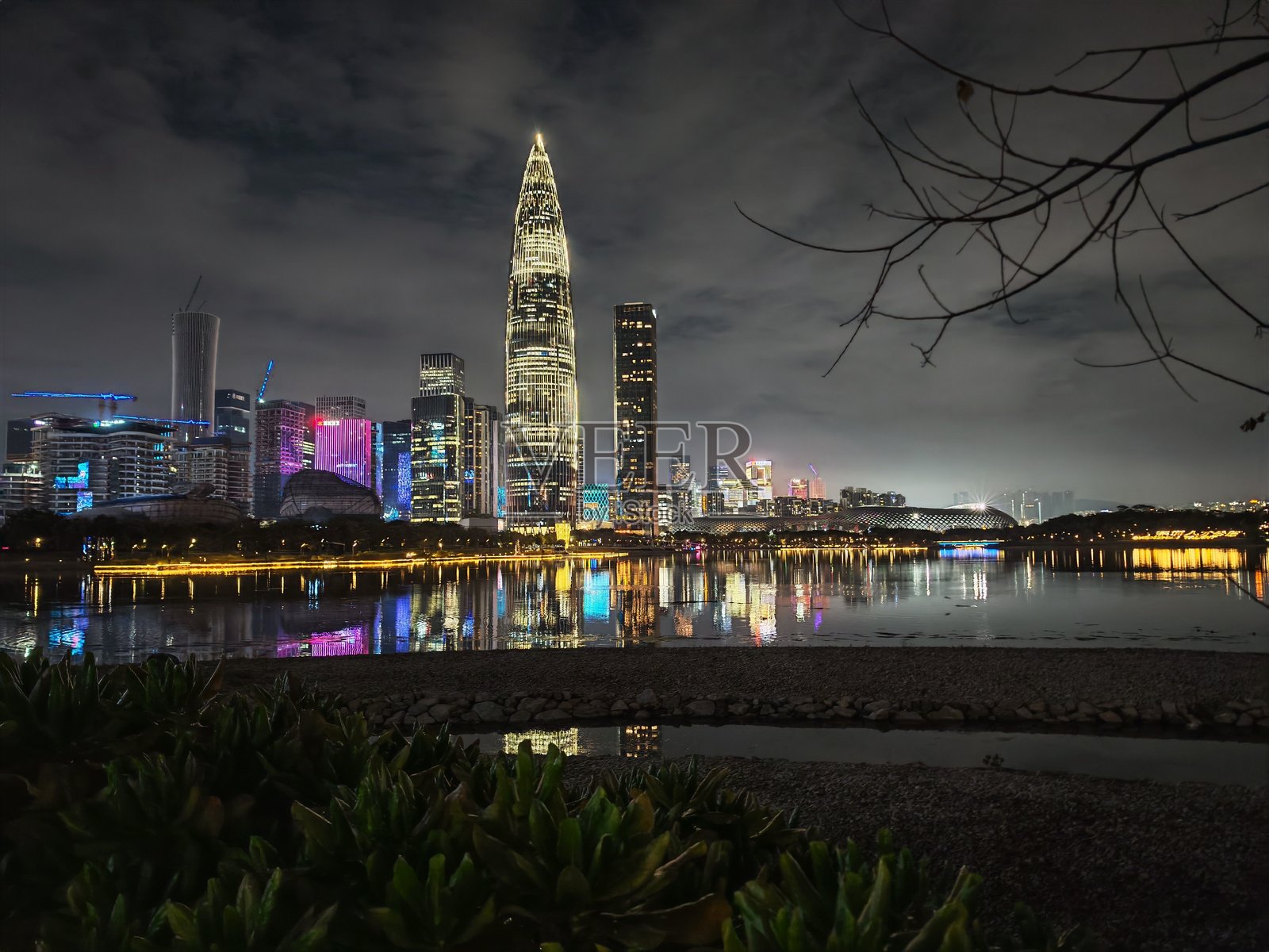 中国深圳的夜景,展示了灯光璀璨的建筑倒映在水面上。城市景观的美丽夜景。照片摄影图片