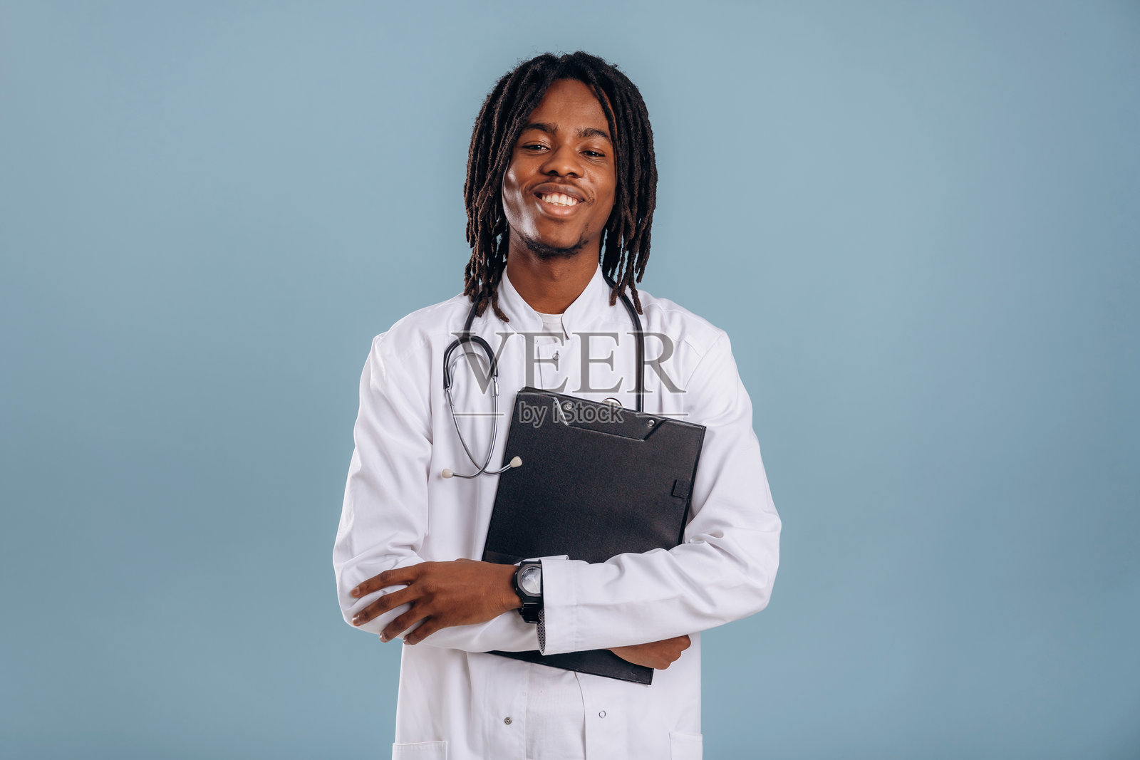 手持记事本的医生。黑人在柔和背景的工作室中。照片摄影图片