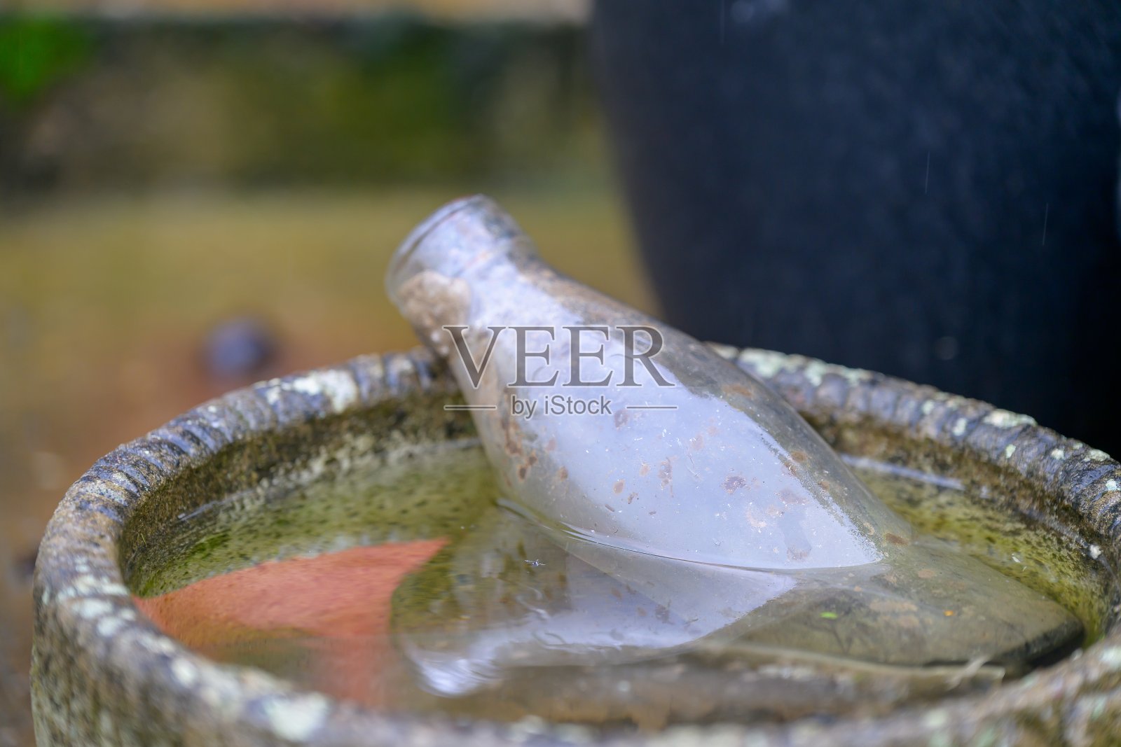 清洁的脏瓶子静静地放在户外的乡村水容器中照片摄影图片