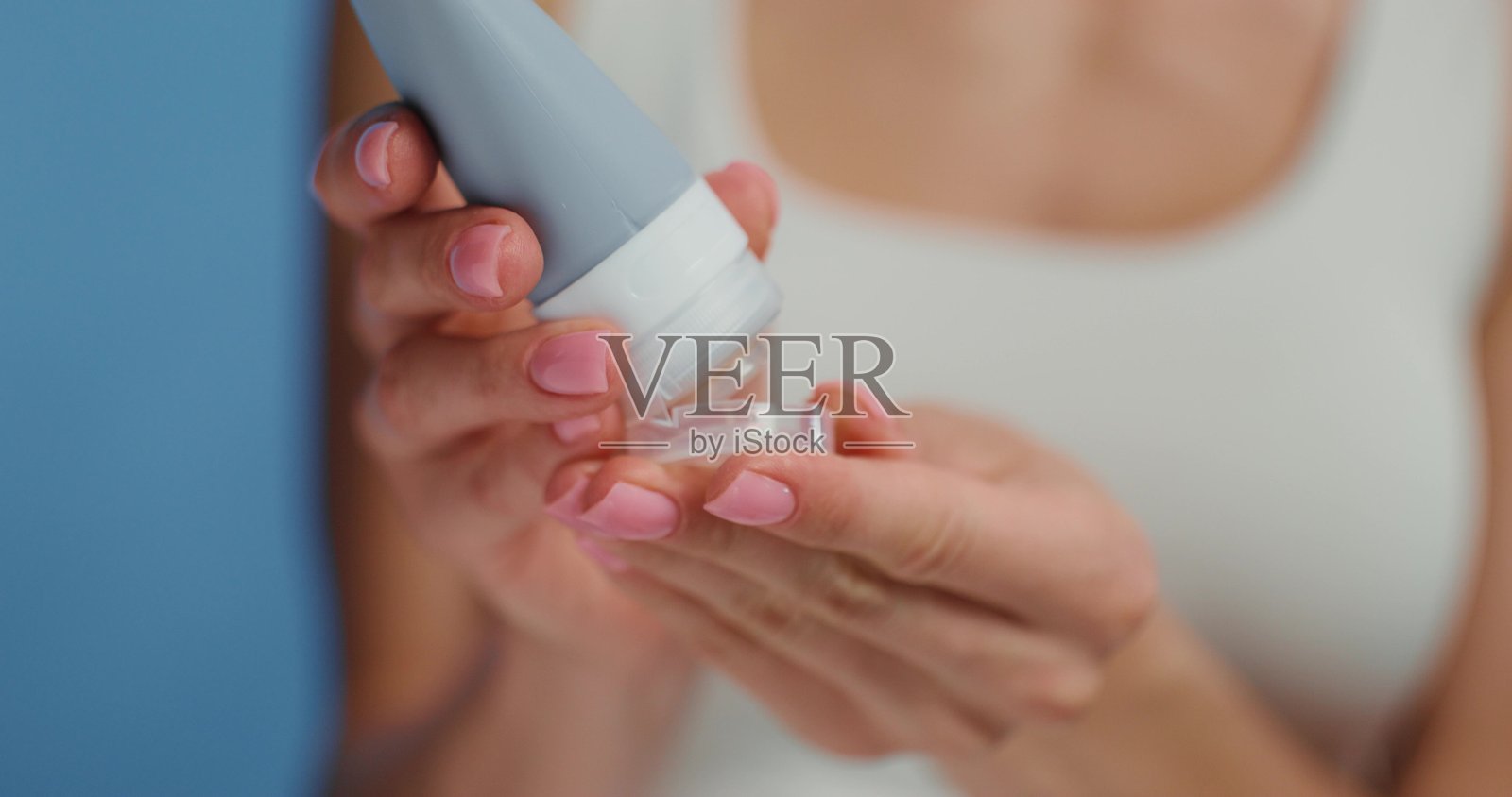 女性的手握着一瓶化妆品照片摄影图片