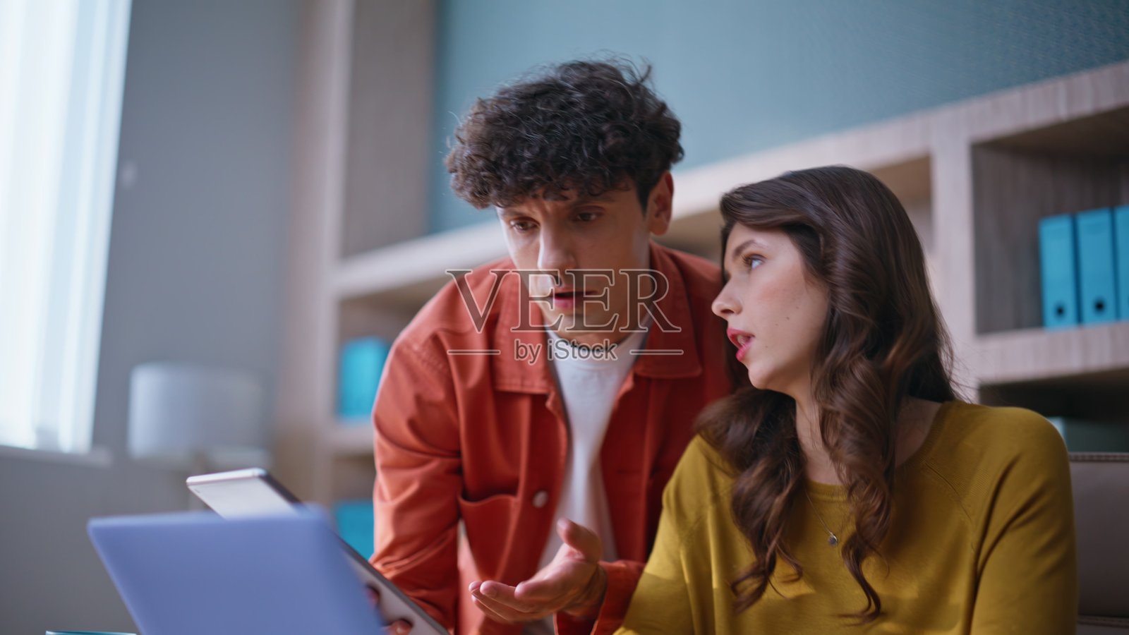 两位同事在办公室里不满地一起看着笔记本电脑，特写镜头。照片摄影图片