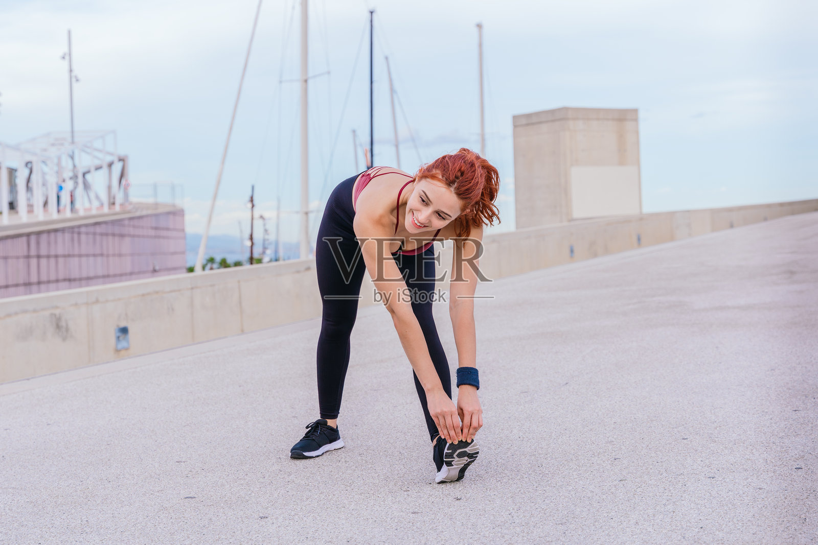 城市环境中伸展的年轻运动女性照片摄影图片