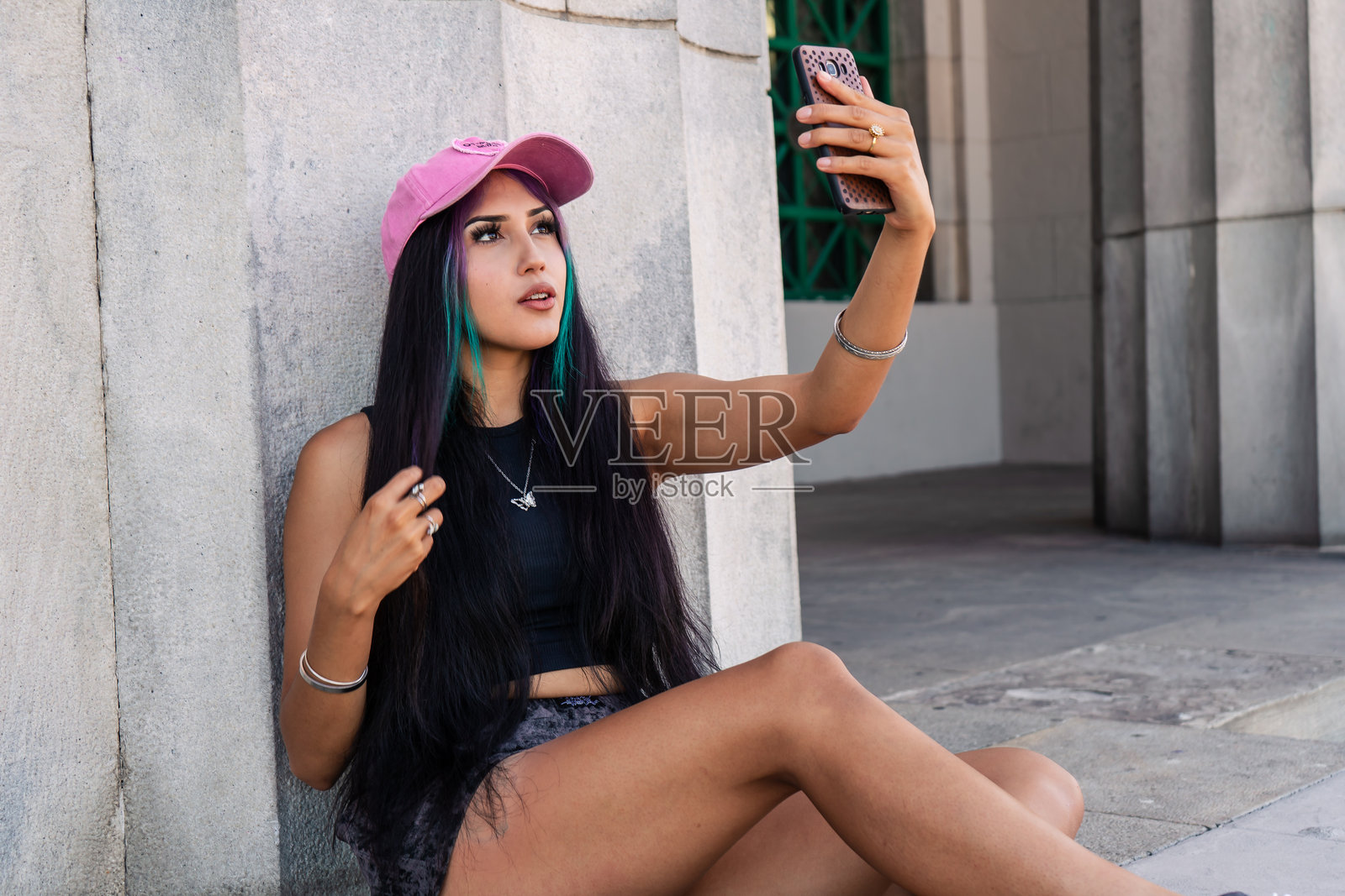 一位年轻女性在楼梯平台上为社交媒体录制故事照片摄影图片