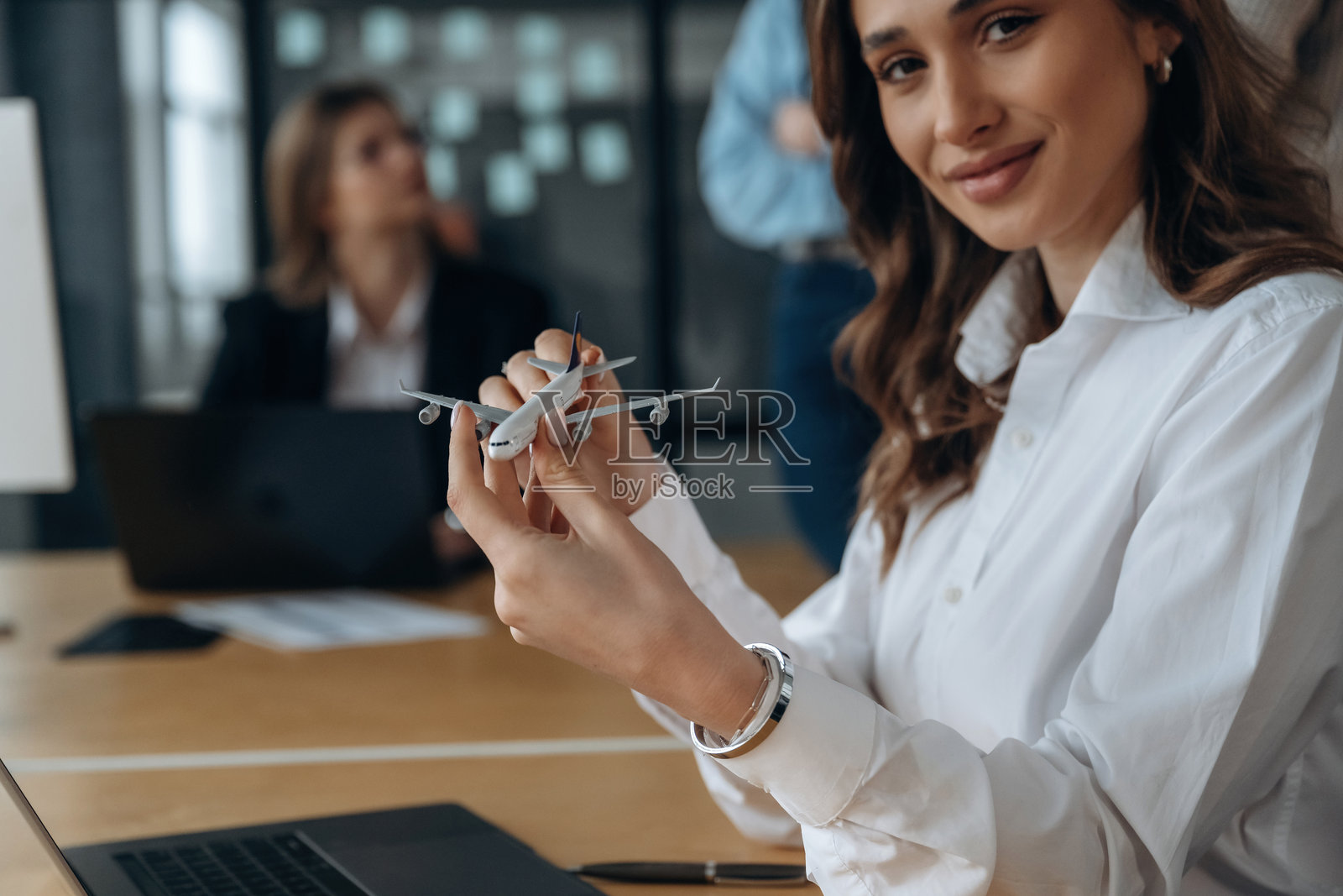 小玩具飞机在手中。商务人士在办公室工作。照片摄影图片